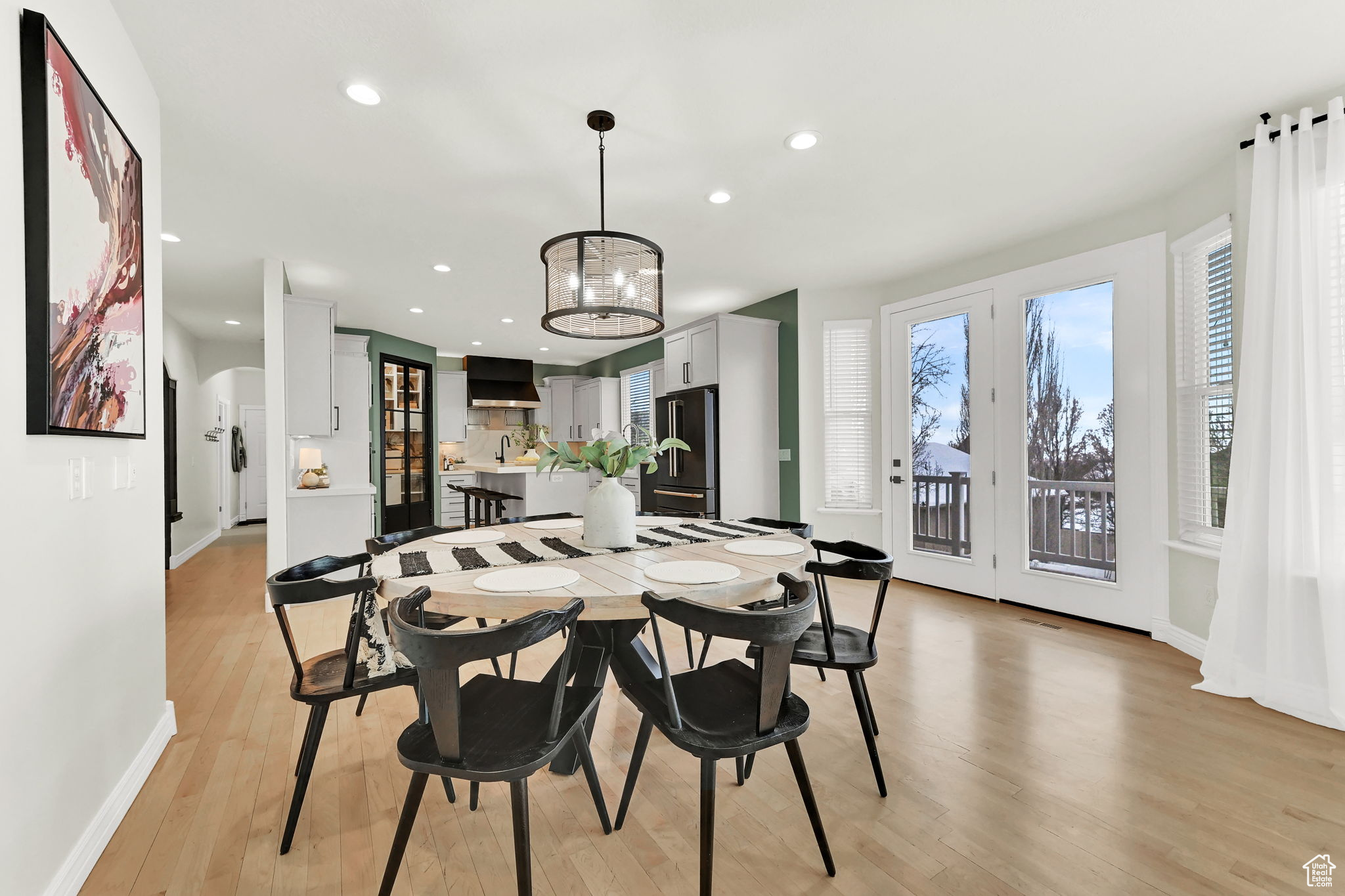 Dining area with light hardwood / wood-style floors and an inviting chandelier