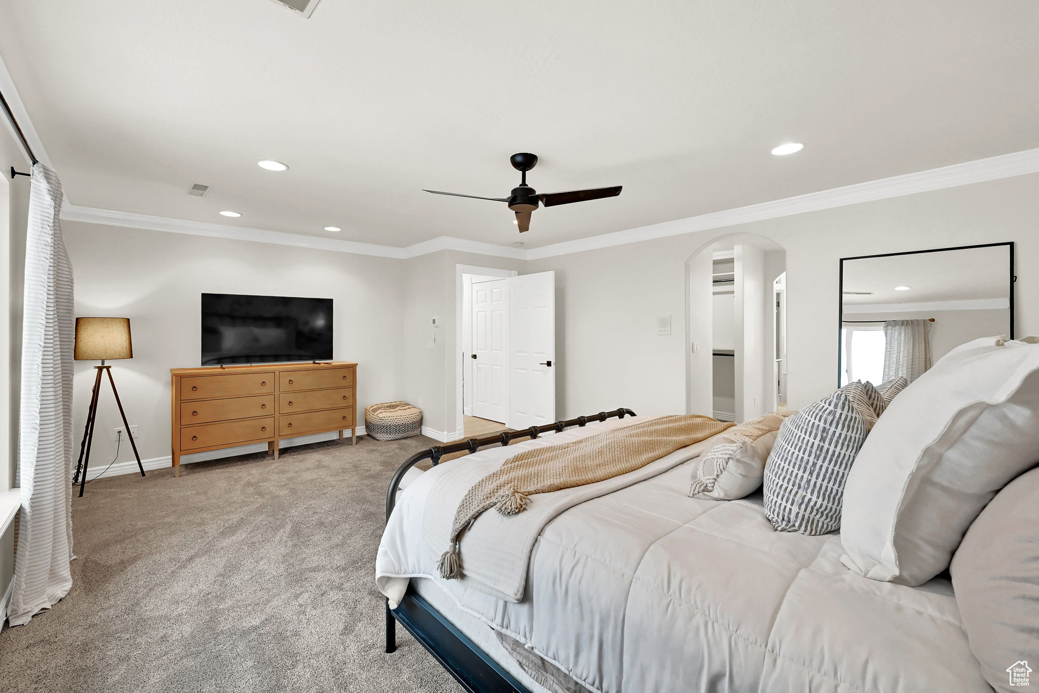 Bedroom featuring ceiling fan, light colored carpet, and ornamental molding