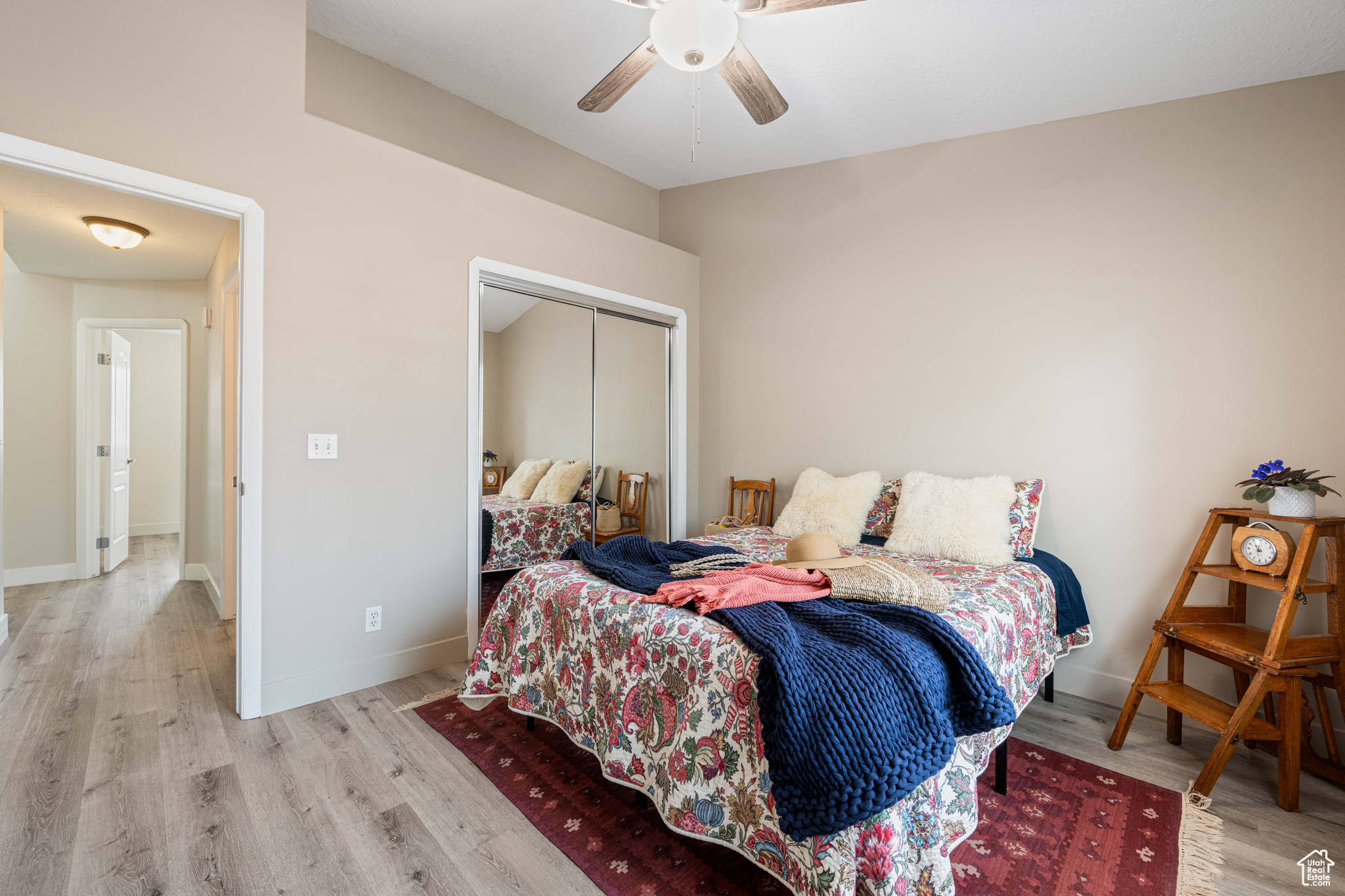 Bedroom featuring a closet, ceiling fan, baseboards, and wood finished floors