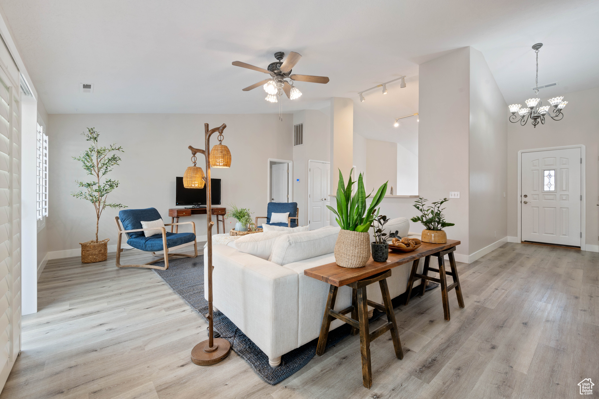 Living room with visible vents, light wood-style flooring, and baseboards