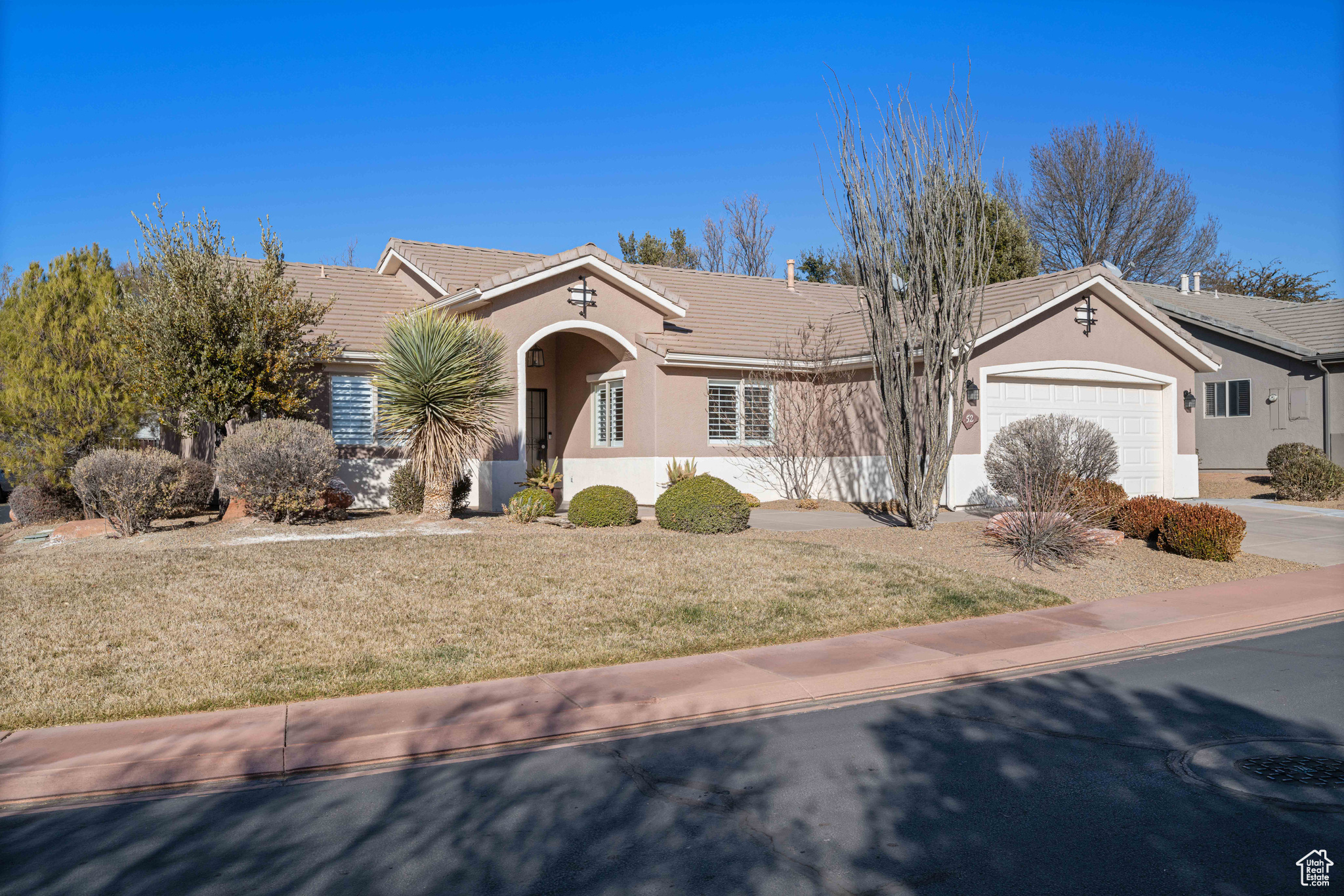 Ranch-style home with a garage and a front lawn