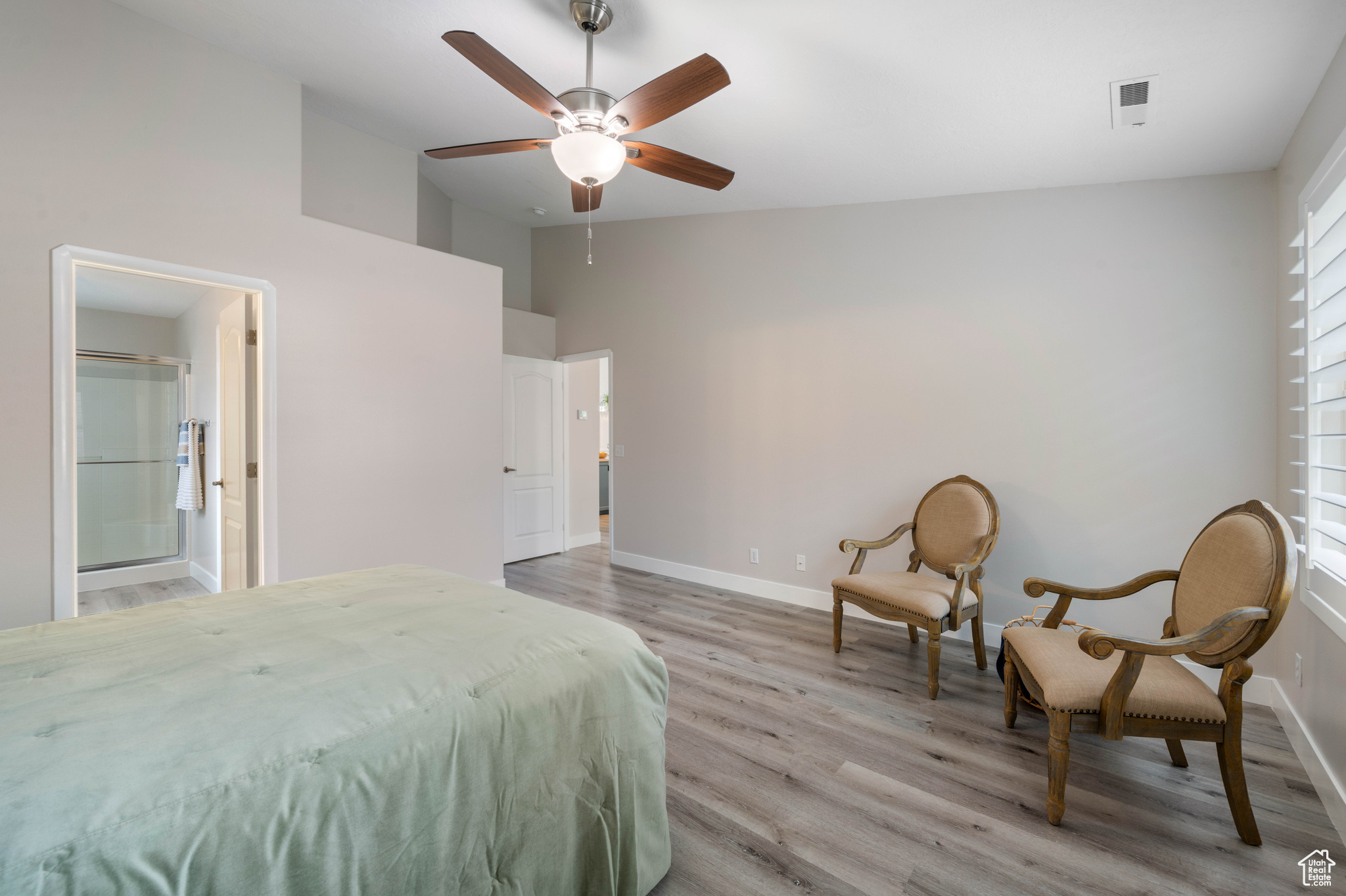 Bedroom with baseboards, light wood-style floors, ceiling fan, and high vaulted ceiling