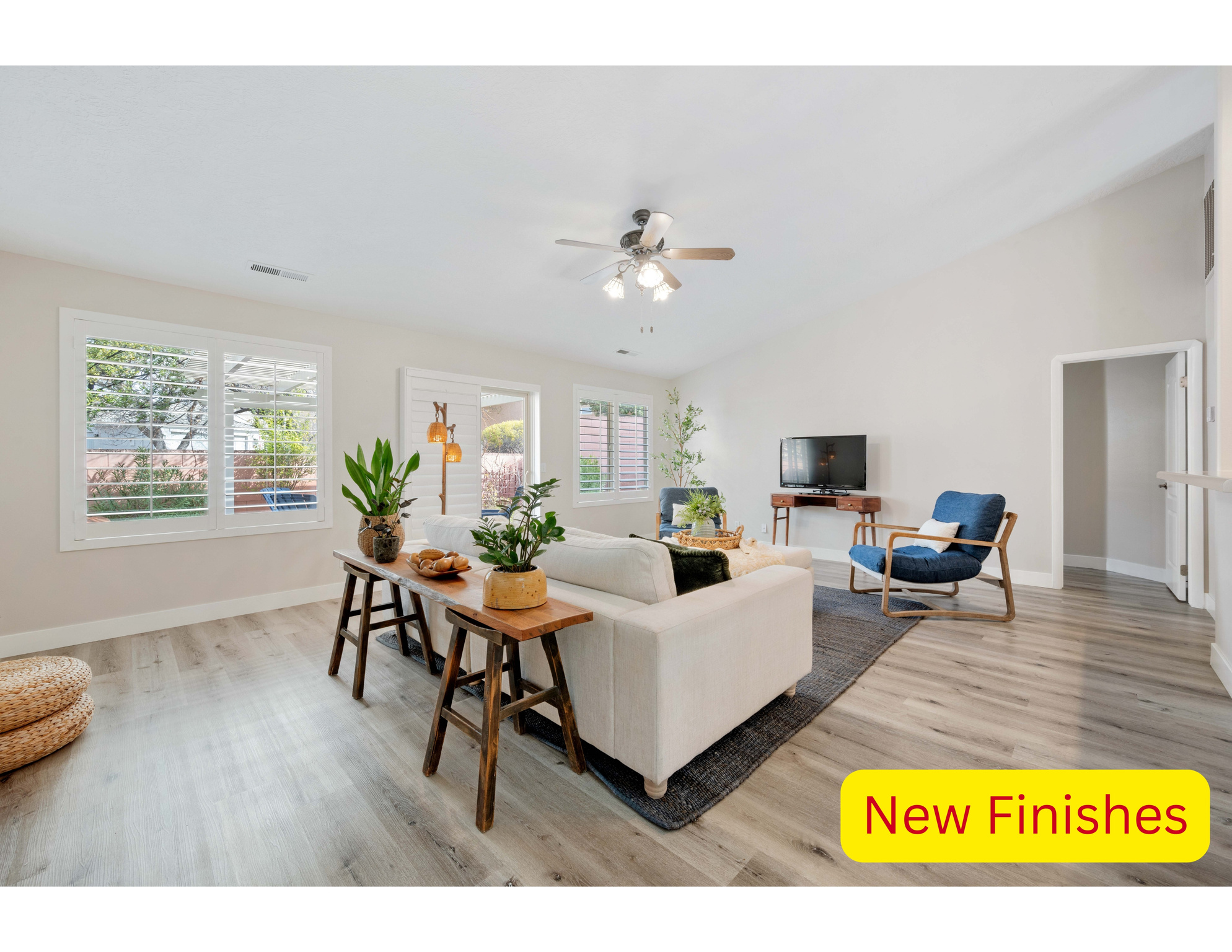 Living area featuring  baseboards, light wood-style floors, and vaulted ceiling