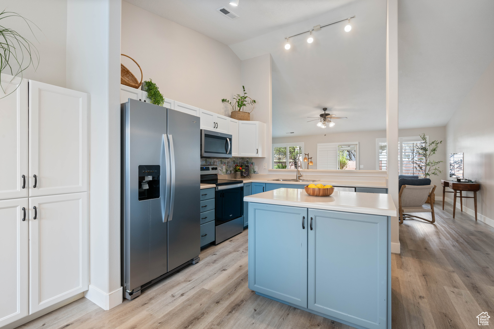 Kitchen featuring visible vents, light countertops, appliances with stainless steel finishes, blue cabinets, and a sink