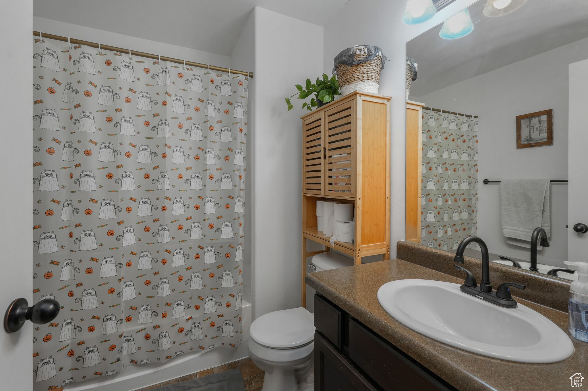 Full bathroom featuring vanity, shower / bath combo, and toilet