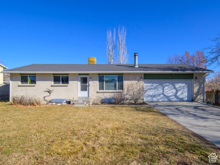 Single story home featuring a front lawn and a garage