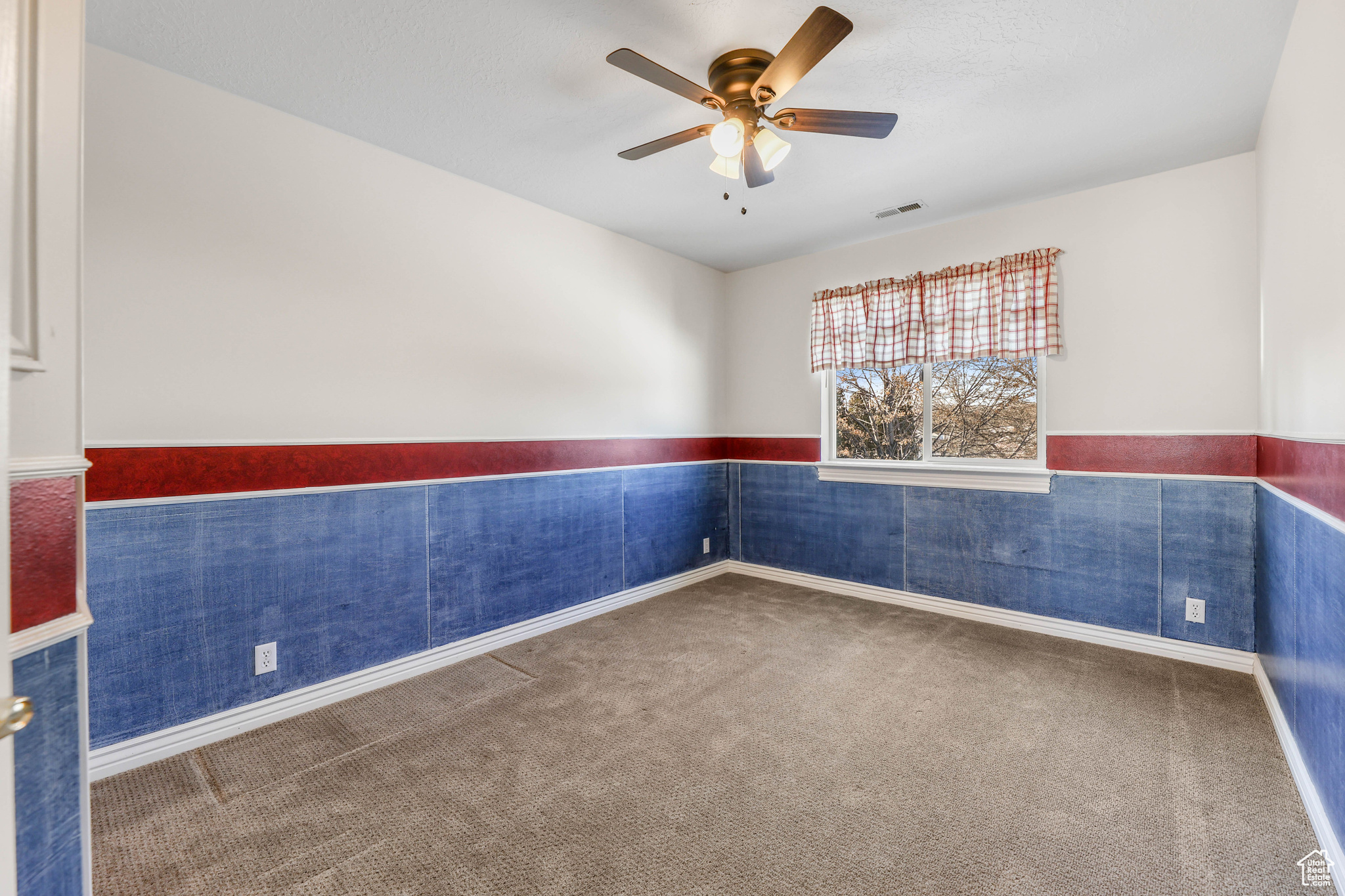Unfurnished room with ceiling fan and carpet