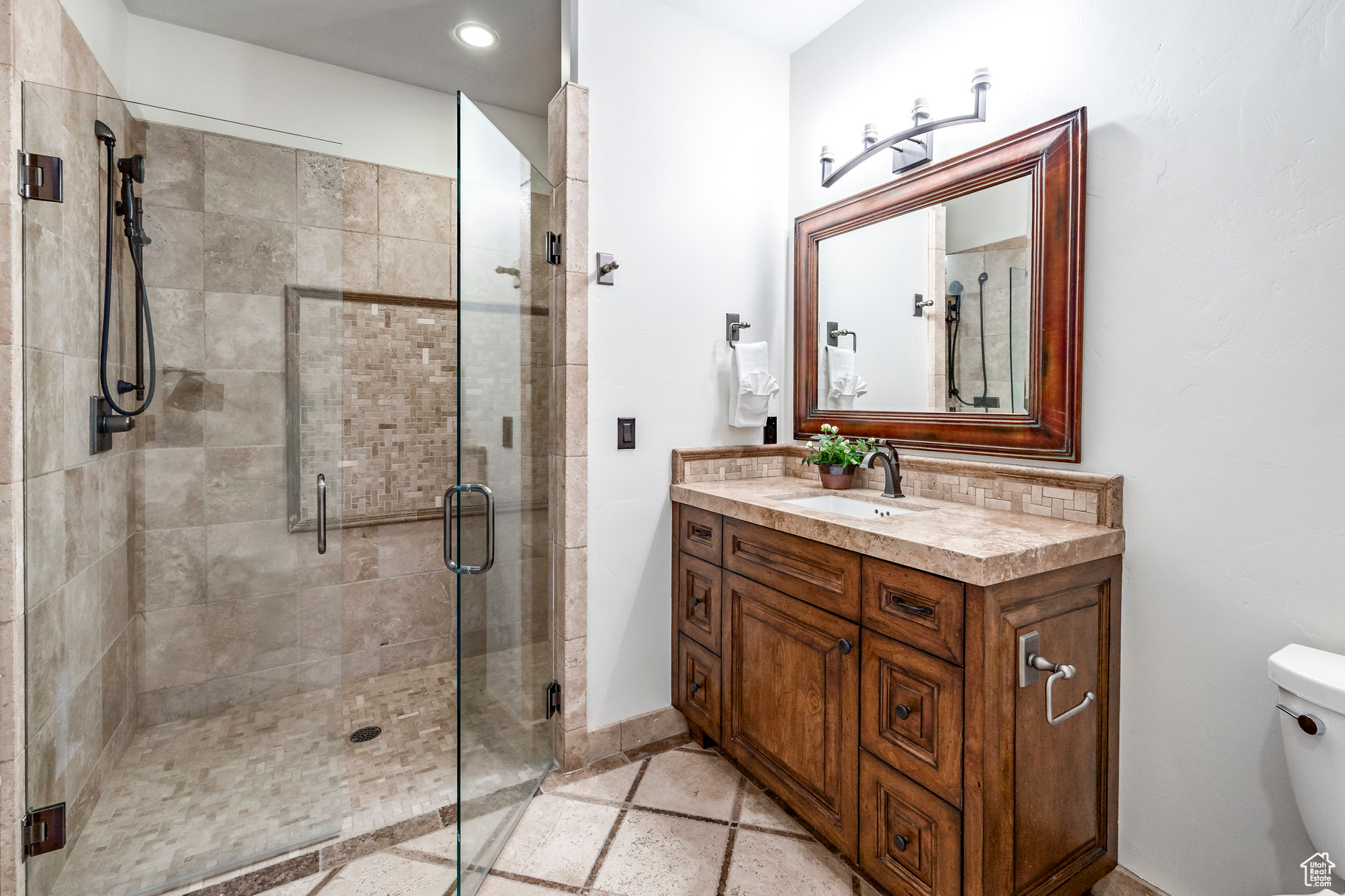 Bathroom featuring vanity, toilet, and an enclosed shower