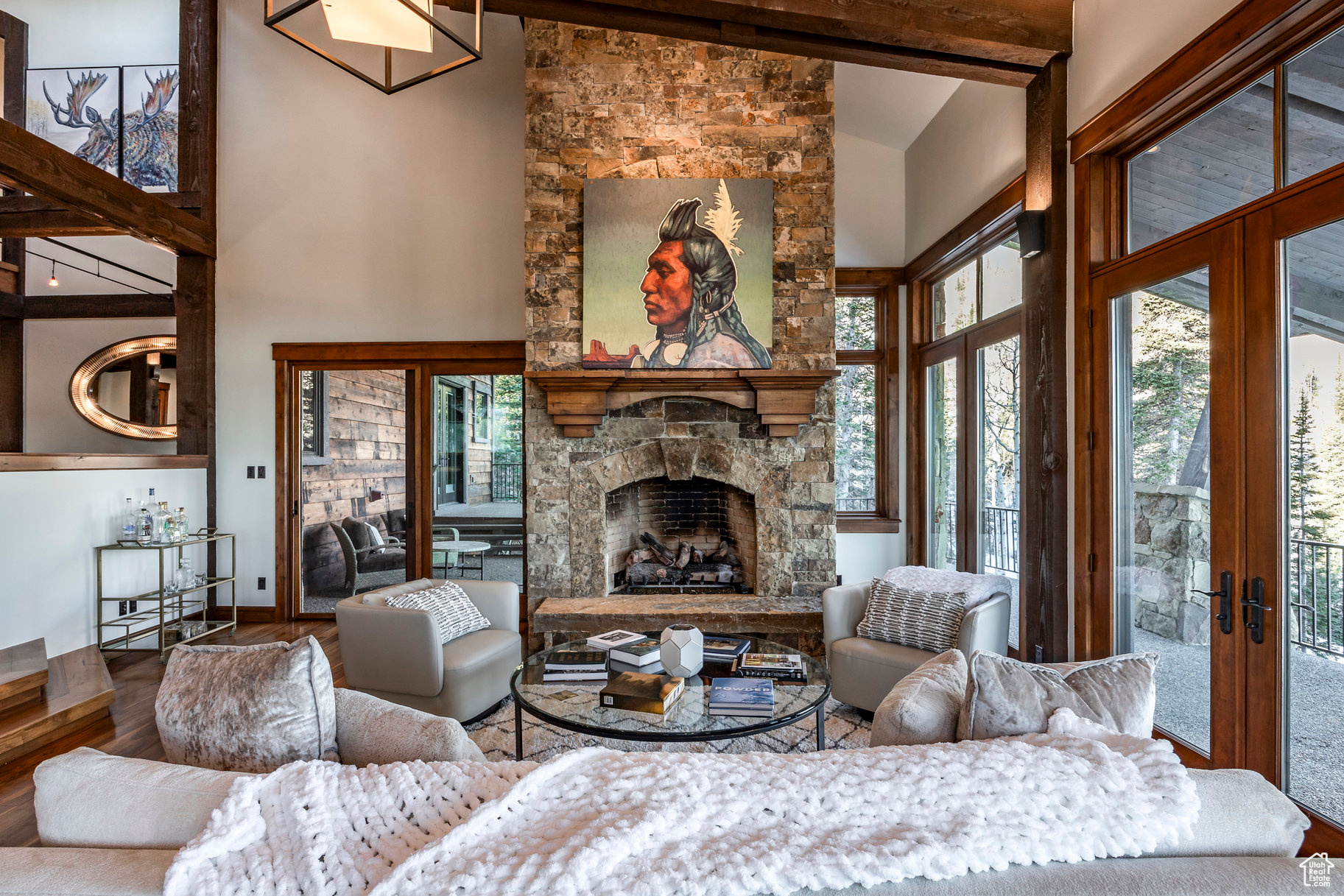 Living room featuring high vaulted ceiling, french doors, a stone fireplace, beamed ceiling, and wood-type flooring
