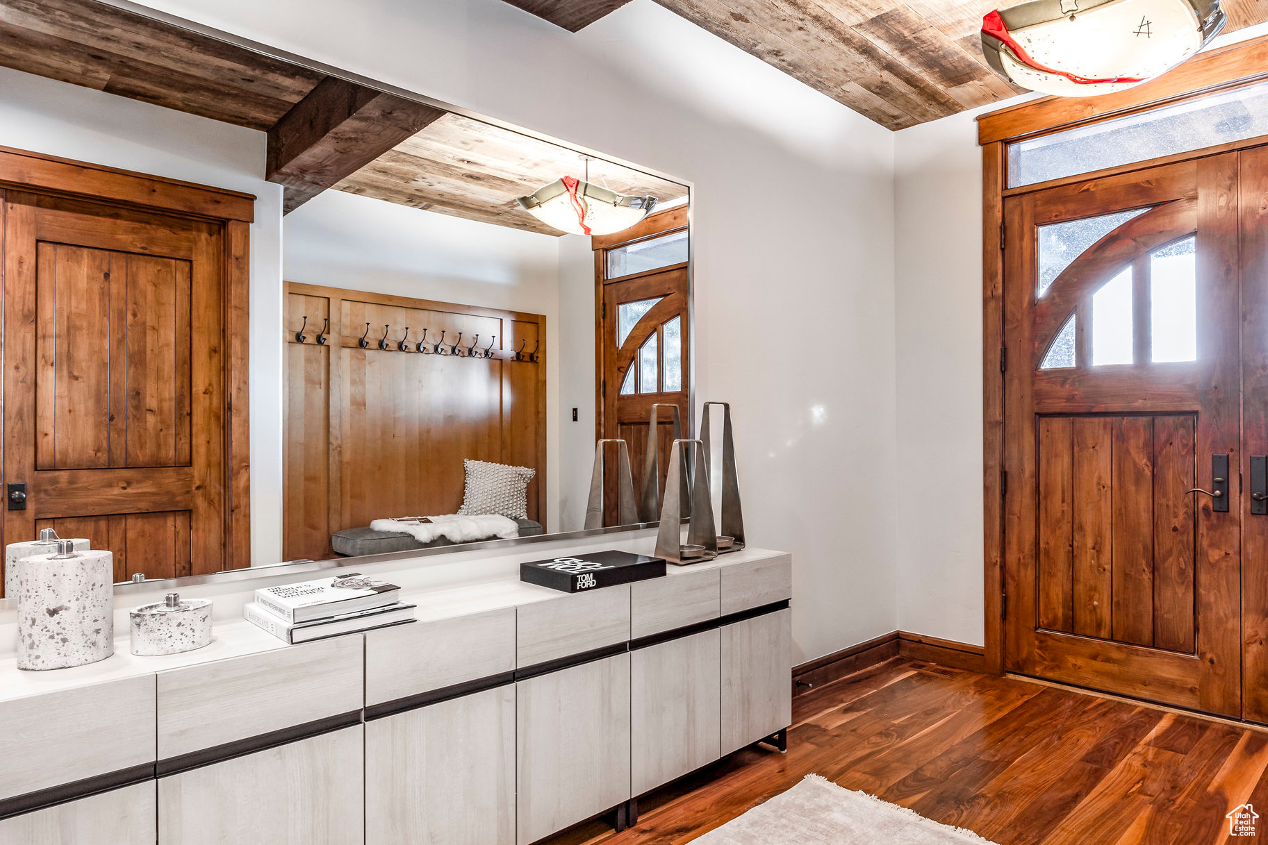 Interior space with beamed ceiling, wood ceiling, and dark hardwood / wood-style floors