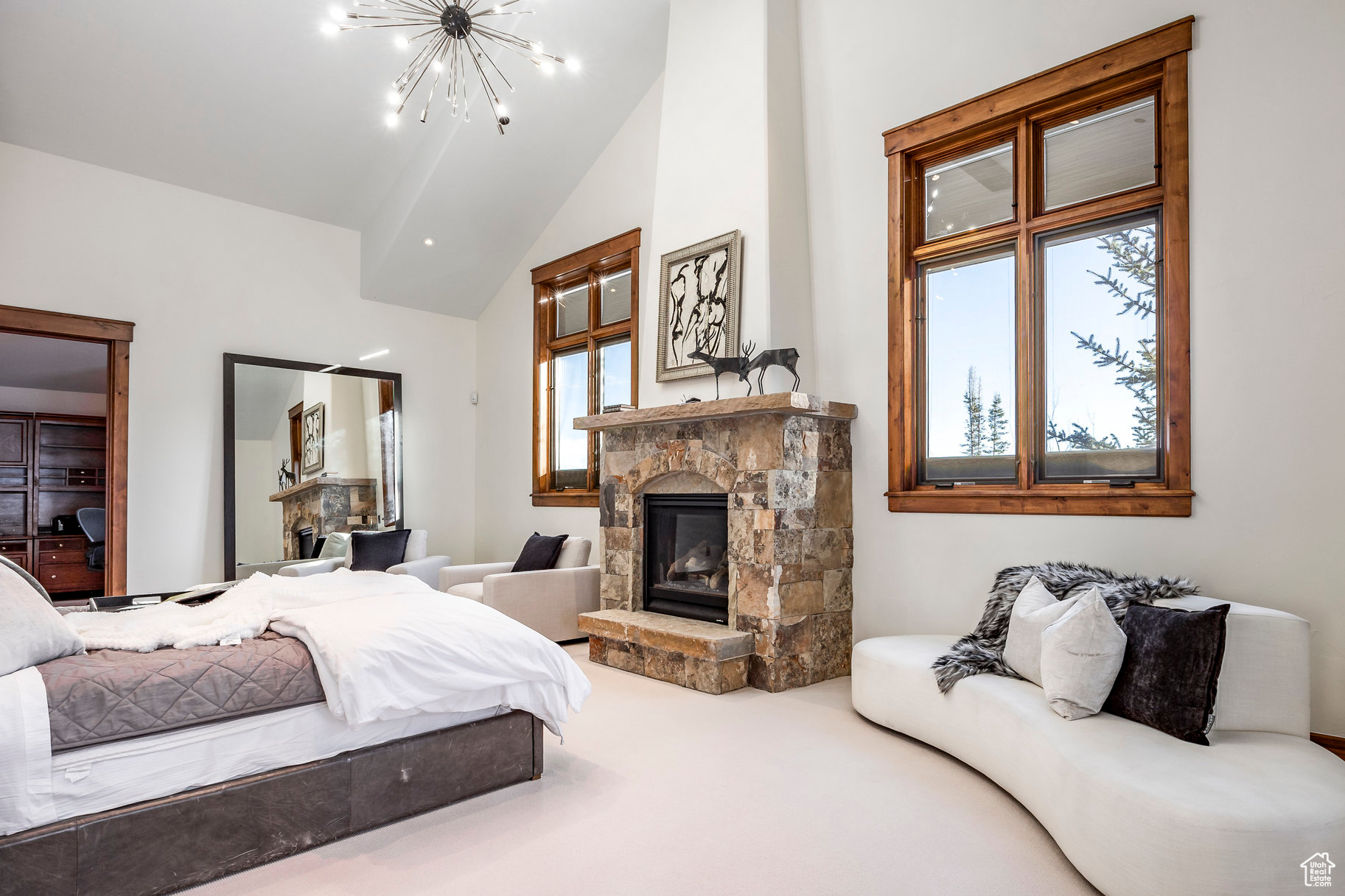 Bedroom with carpet, a notable chandelier, a fireplace, and vaulted ceiling