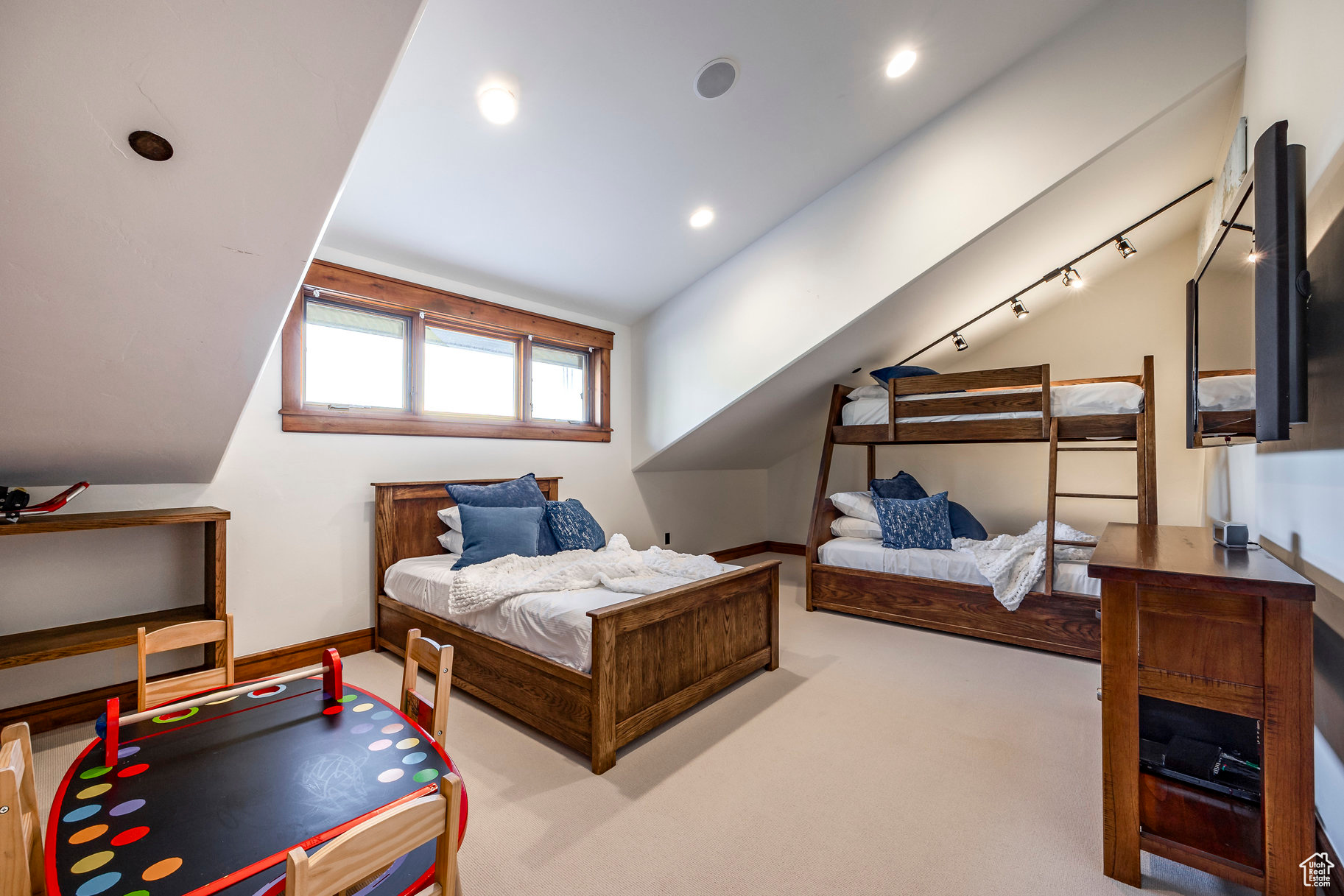 Bedroom with light colored carpet and lofted ceiling