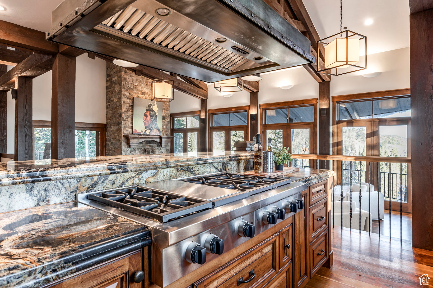 Kitchen with hardwood / wood-style floors, plenty of natural light, stainless steel gas stovetop, and custom exhaust hood