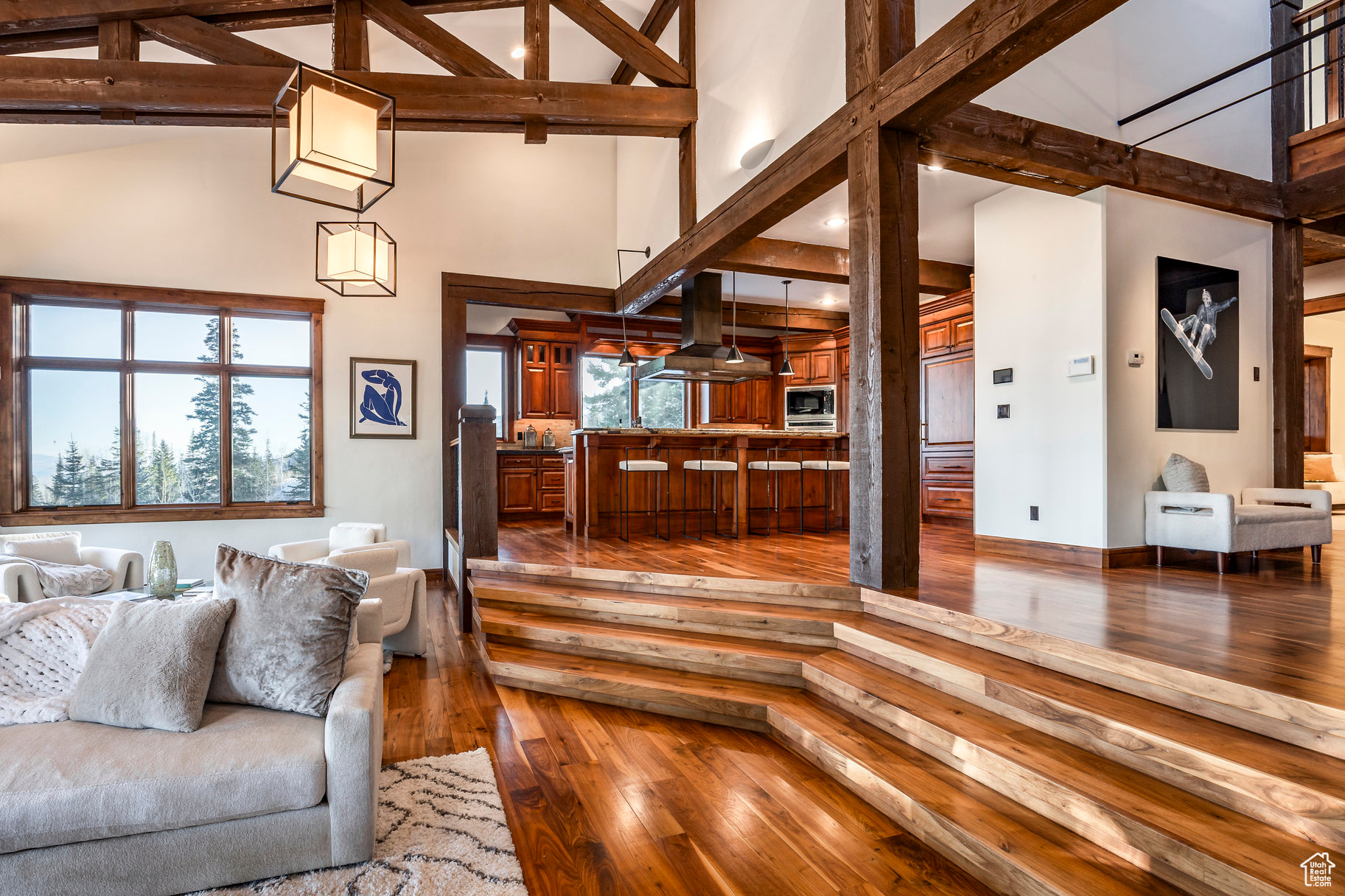 Living room with hardwood / wood-style flooring, high vaulted ceiling, and a healthy amount of sunlight