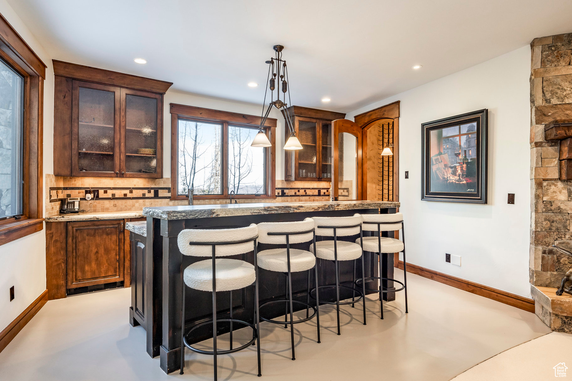 Kitchen featuring a kitchen bar, decorative backsplash, a kitchen island, and decorative light fixtures
