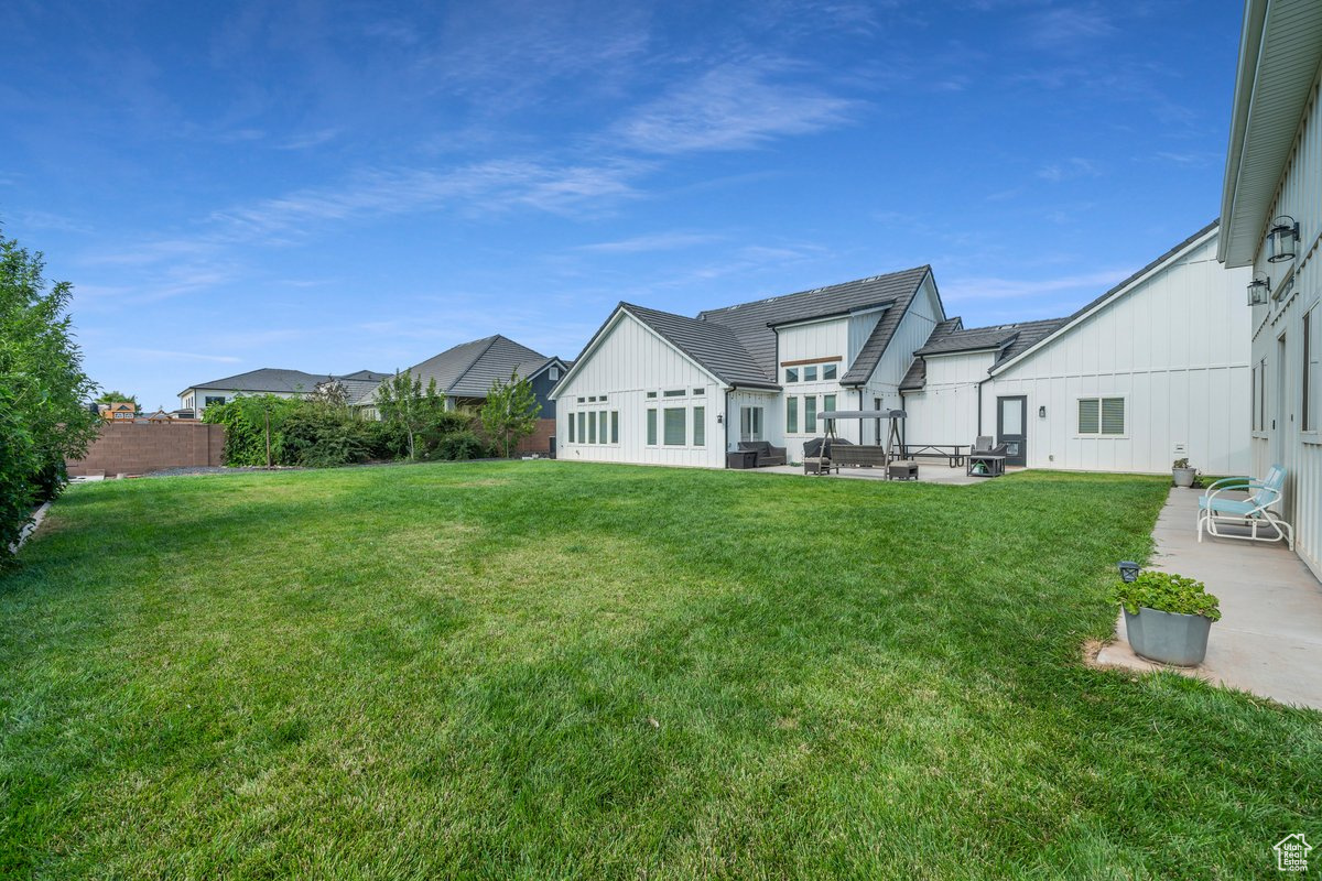 Rear view of property featuring a yard and a patio