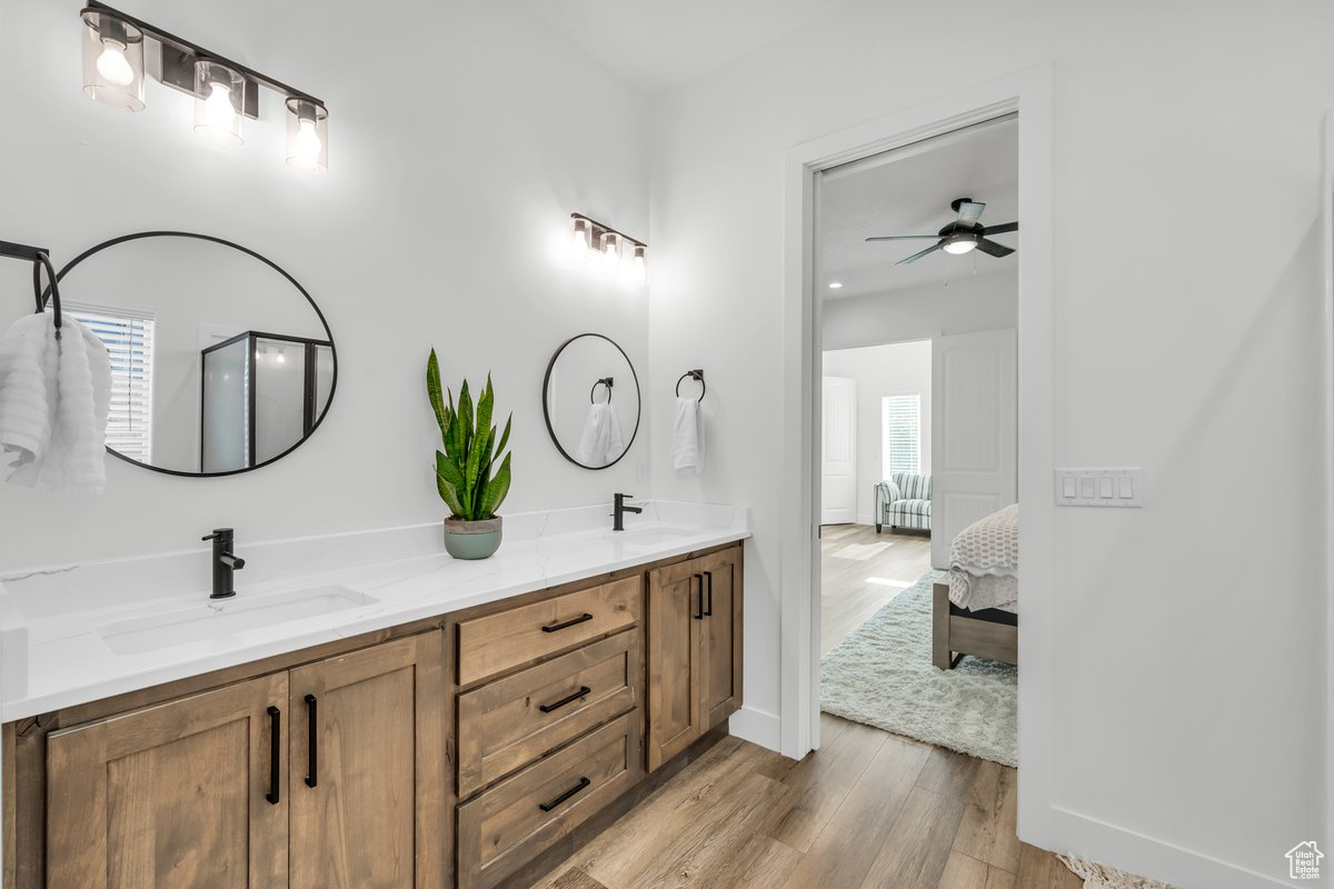 Bathroom featuring walk in shower, ceiling fan, vanity, and hardwood / wood-style flooring