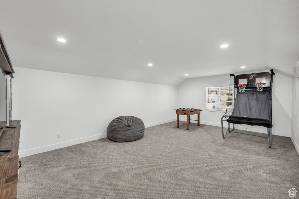 Sitting room featuring carpet flooring and vaulted ceiling