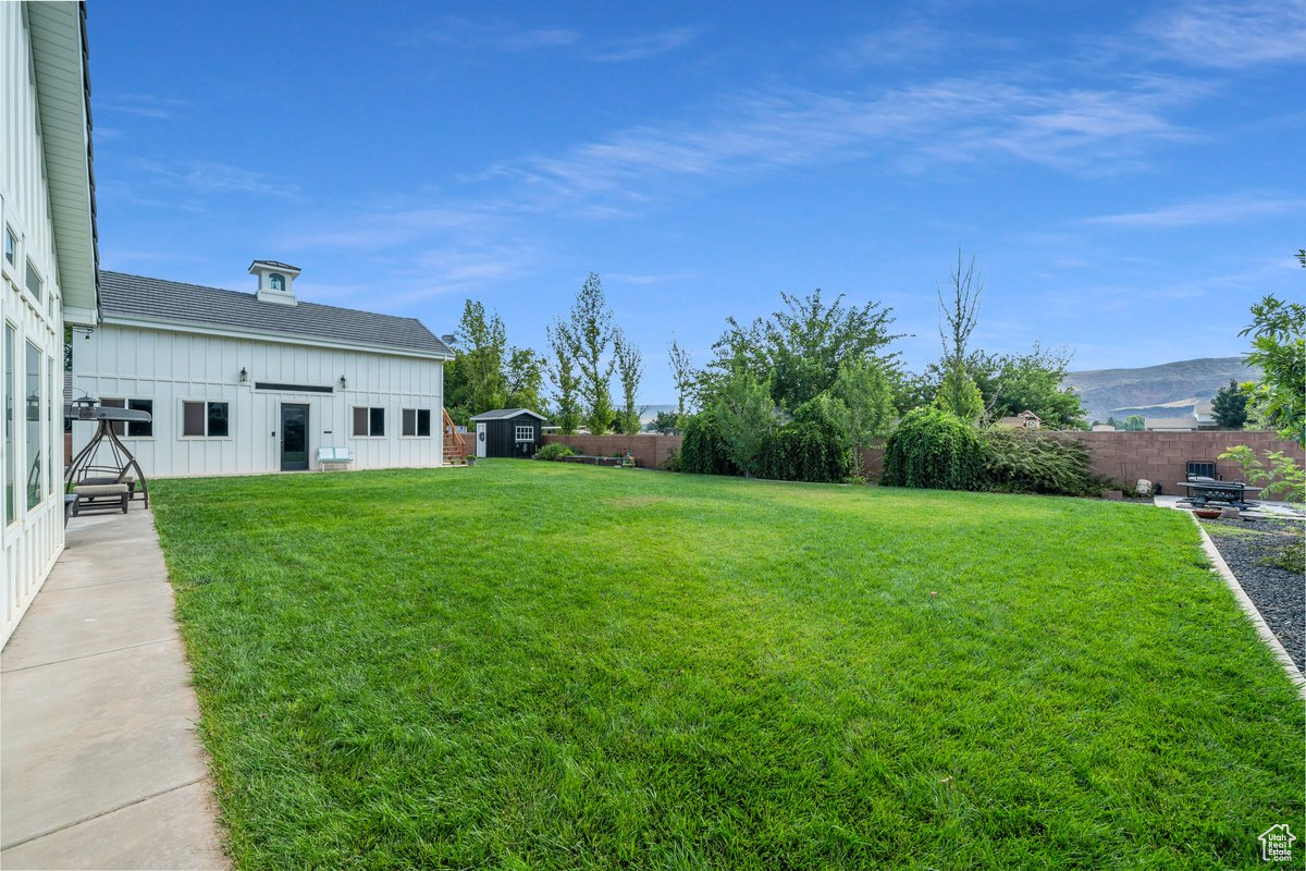 View of yard featuring a mountain view and a storage unit