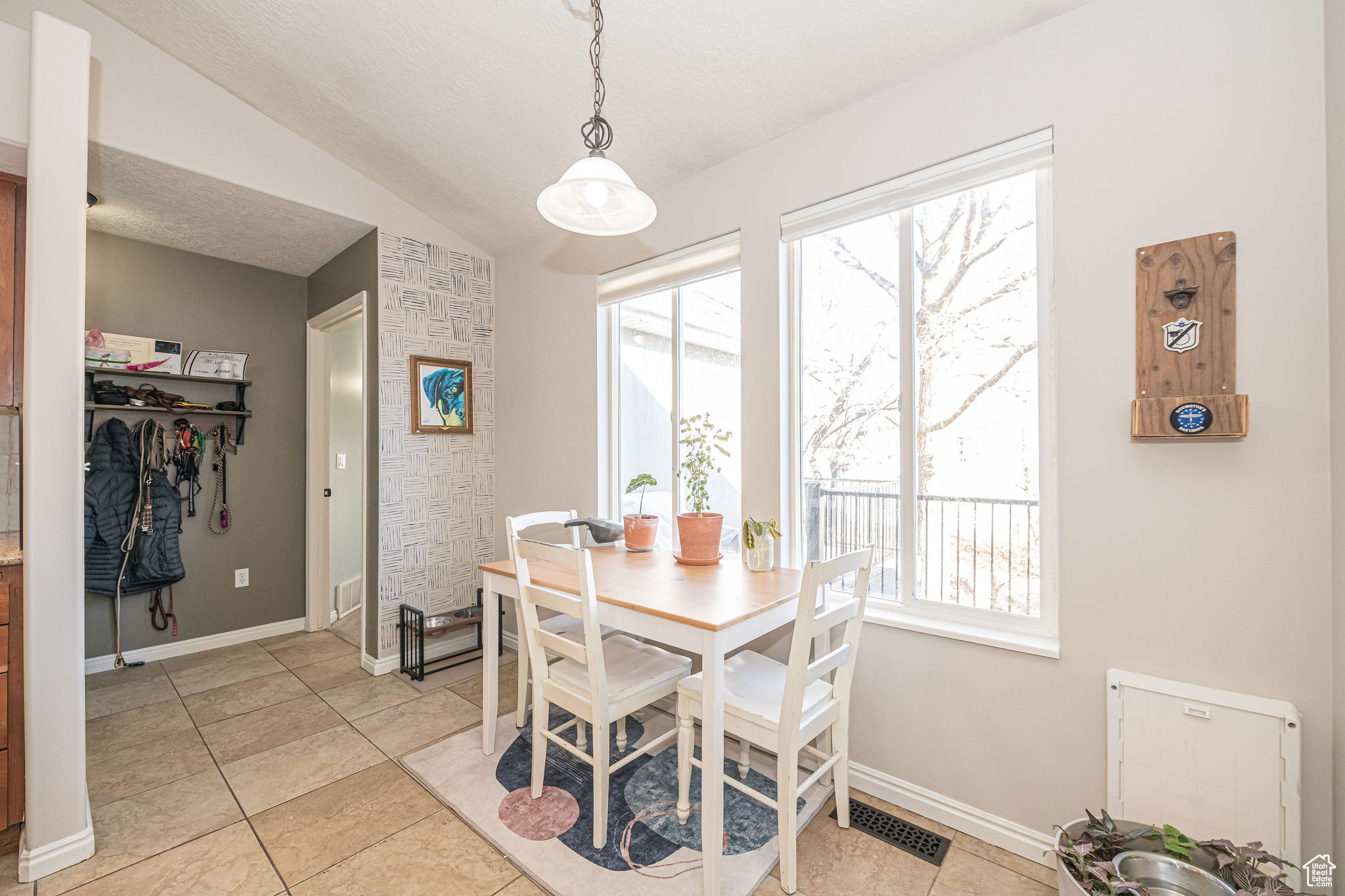 Dining space featuring light tile patterned floors and vaulted ceiling