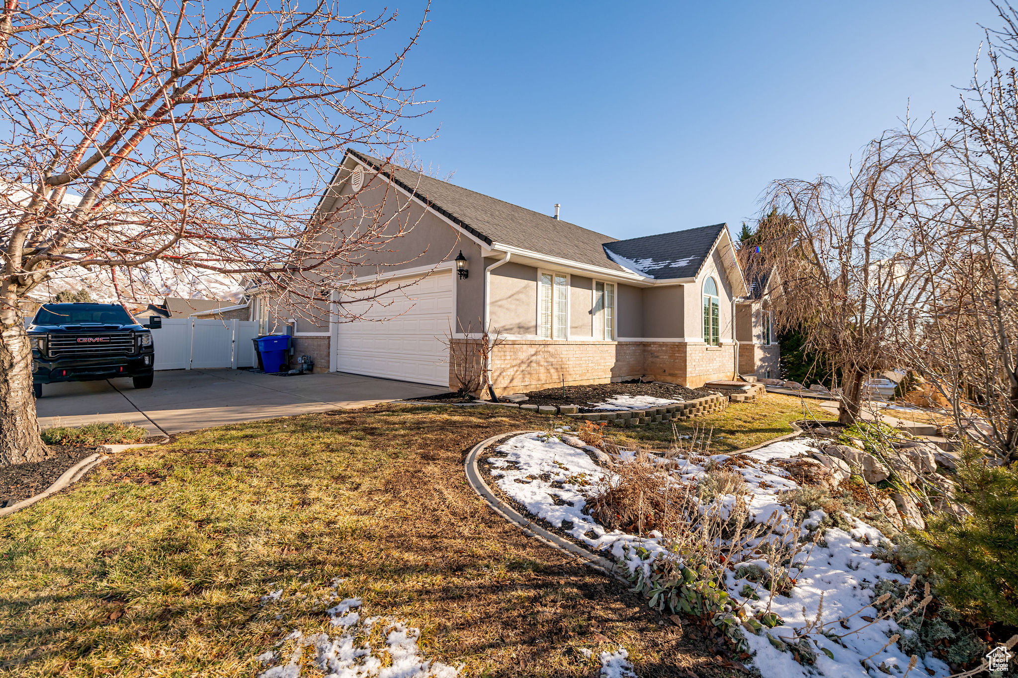 View of side of property with a garage and a lawn