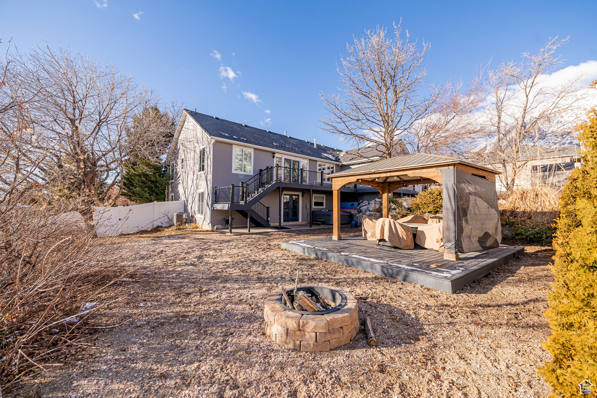 Back of house with a gazebo, a wooden deck, and a fire pit