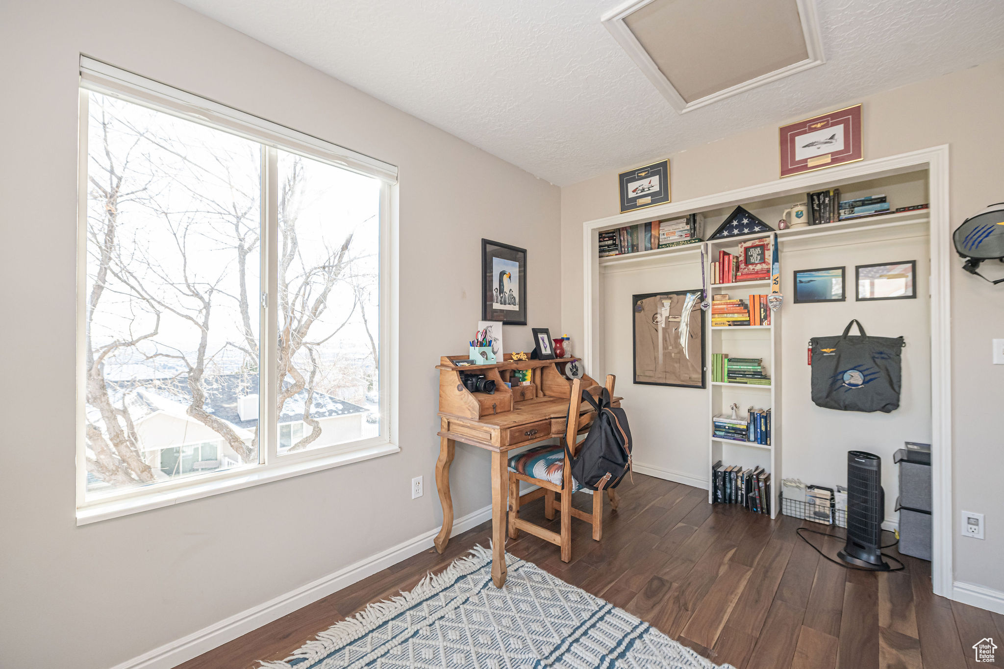 Office with dark hardwood / wood-style flooring and a textured ceiling