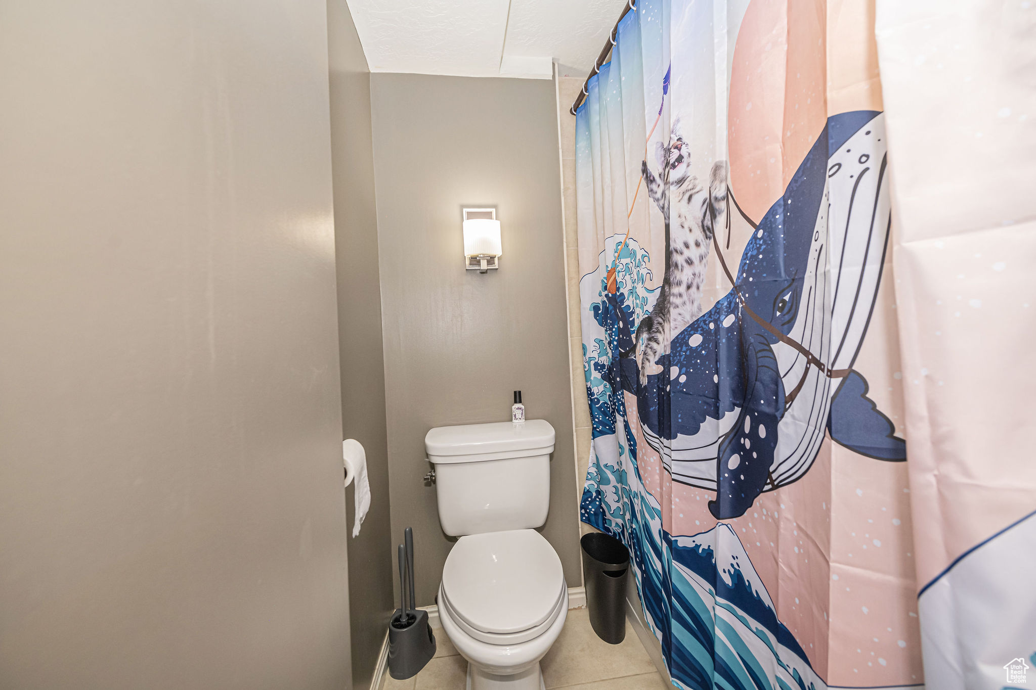 Bathroom featuring tile patterned flooring, toilet, and a shower with shower curtain