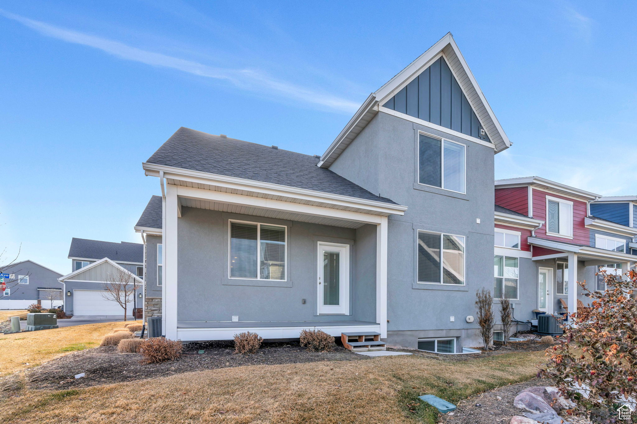 Rear view of property with a yard, central AC unit, and a garage