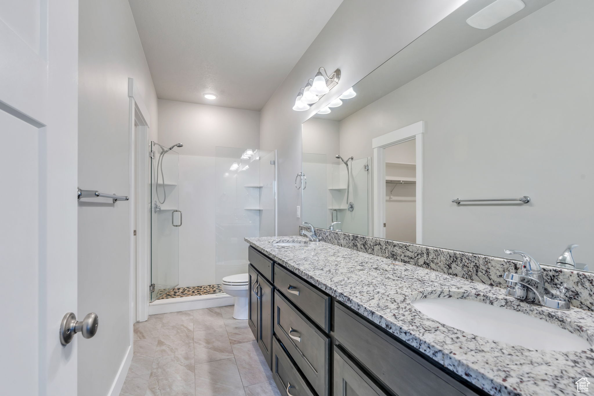 Bathroom with toilet, an enclosed shower, and vanity