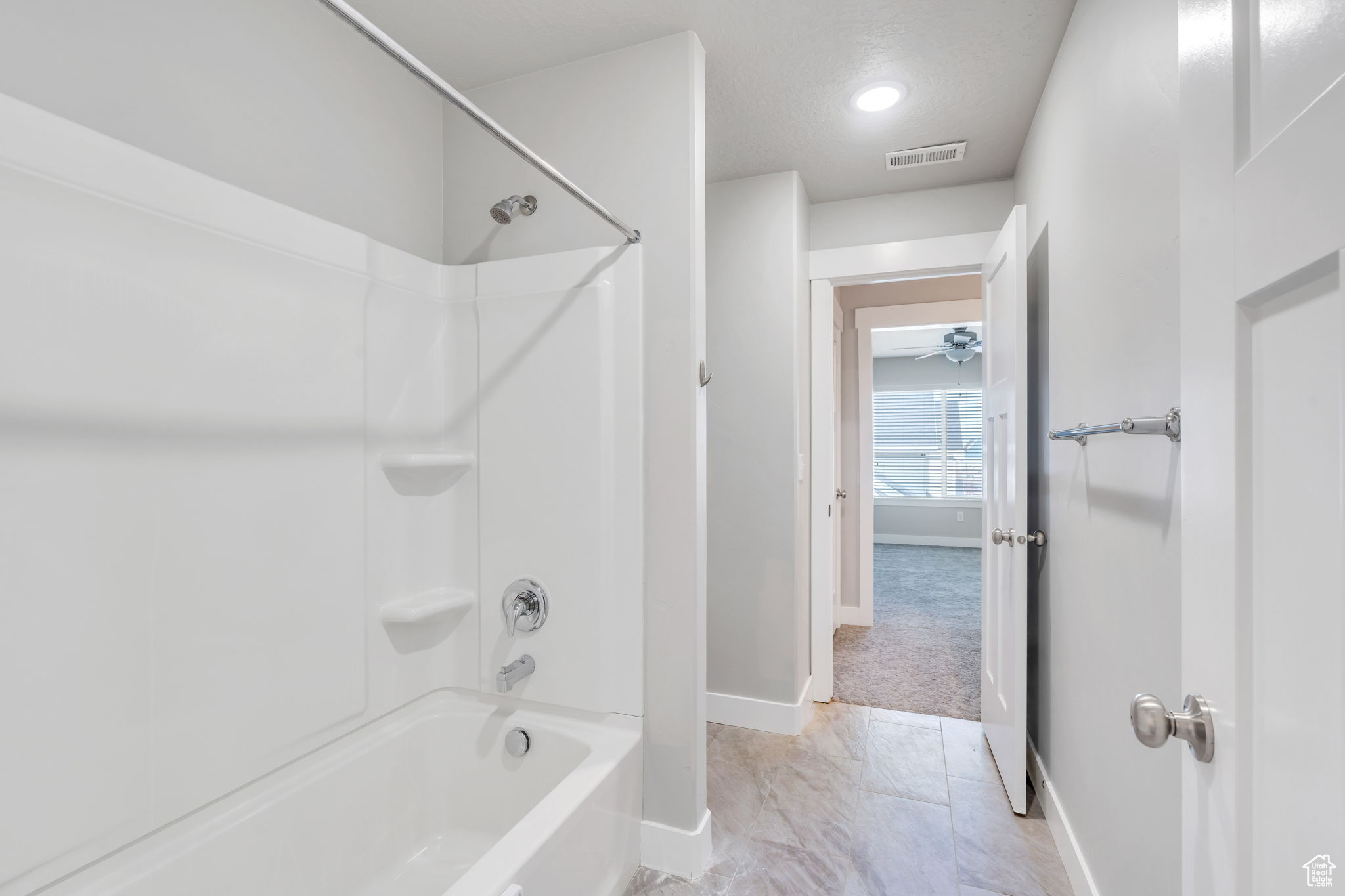 Bathroom featuring shower / bathing tub combination and a textured ceiling