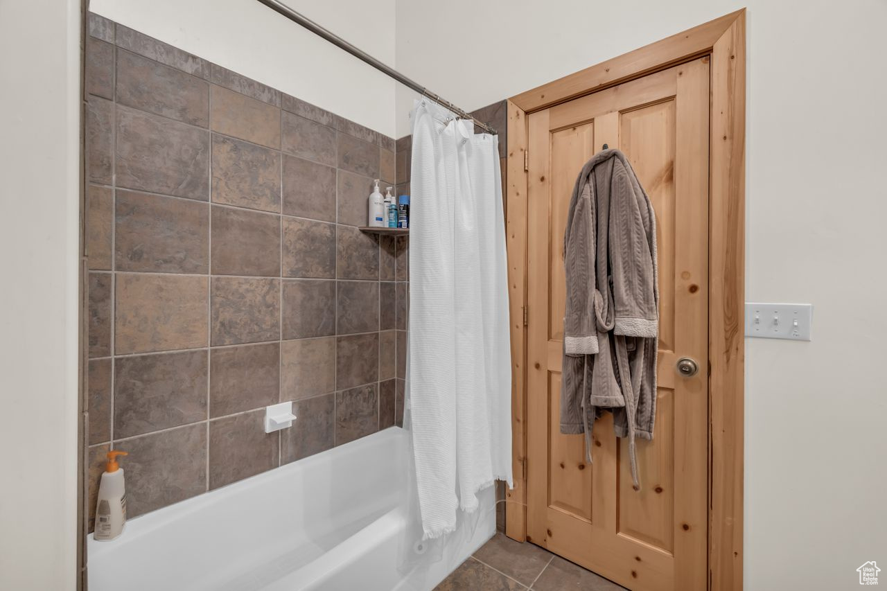 Bathroom with shower / tub combo and tile patterned floors