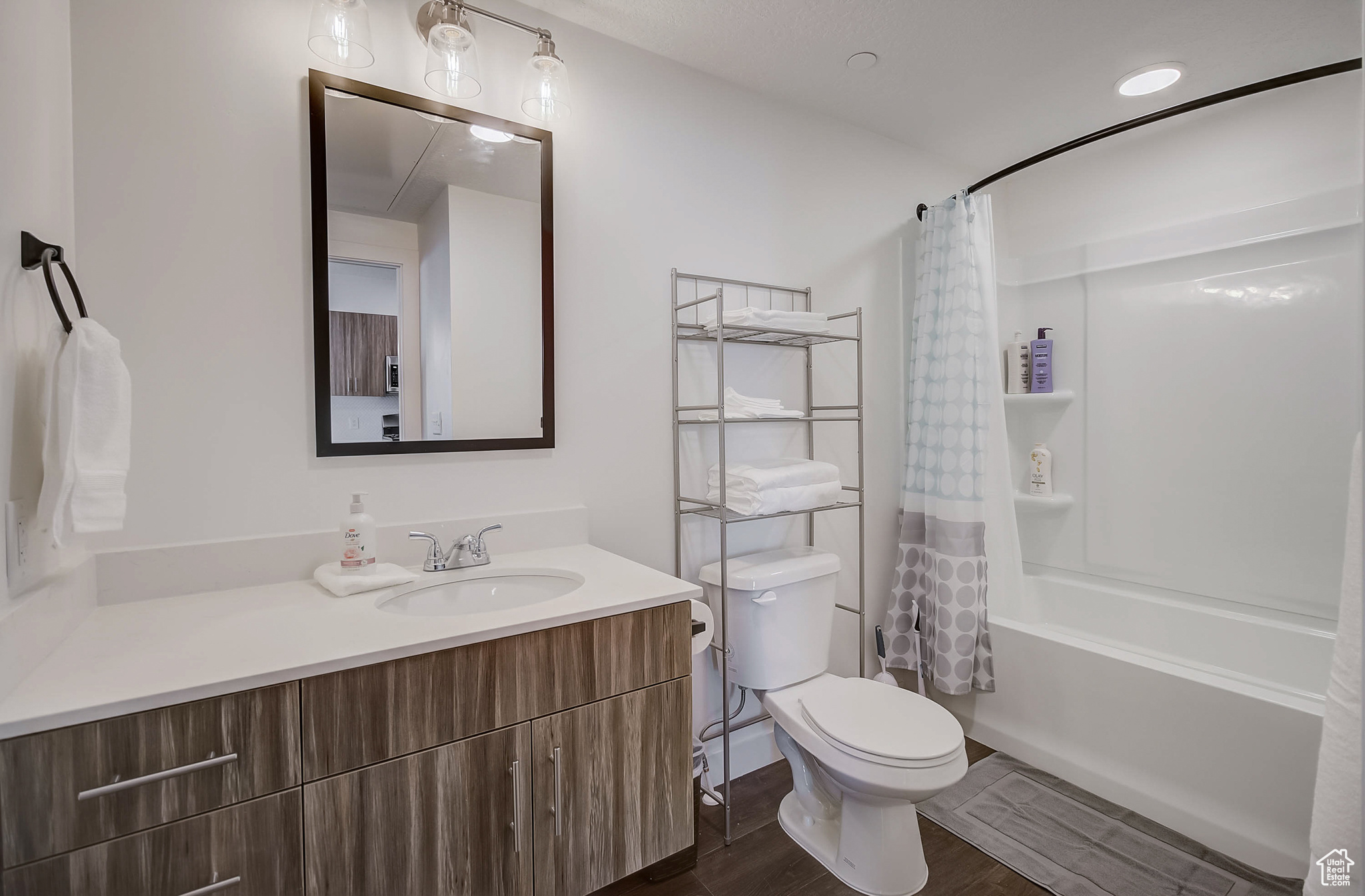 Full bathroom featuring vanity, toilet, wood-type flooring, and shower / tub combo with curtain