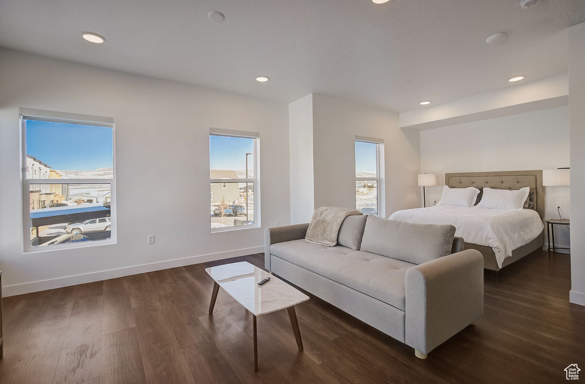 Bedroom with multiple windows and dark wood-type flooring