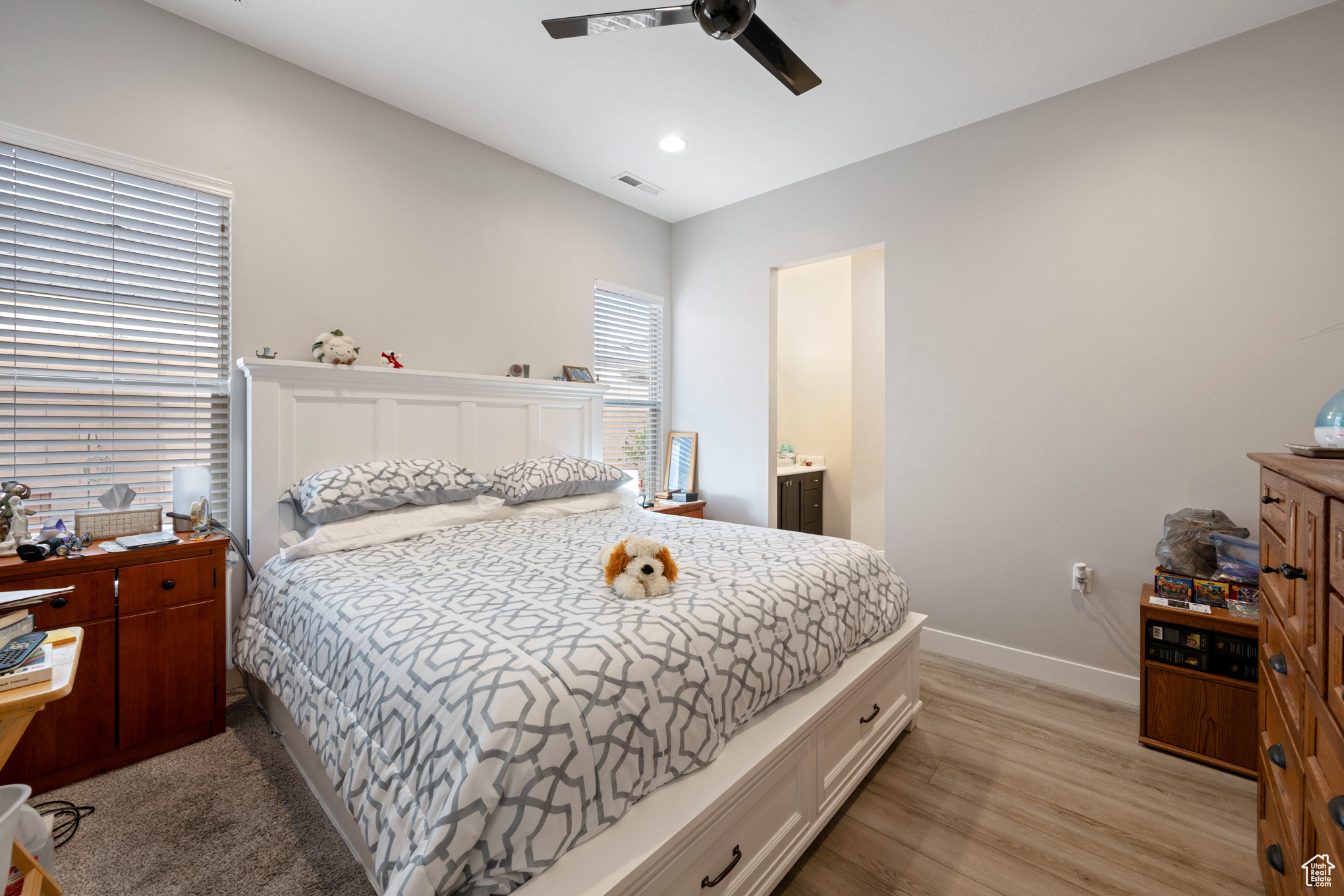 Bedroom with connected bathroom, ceiling fan, and light hardwood / wood-style floors