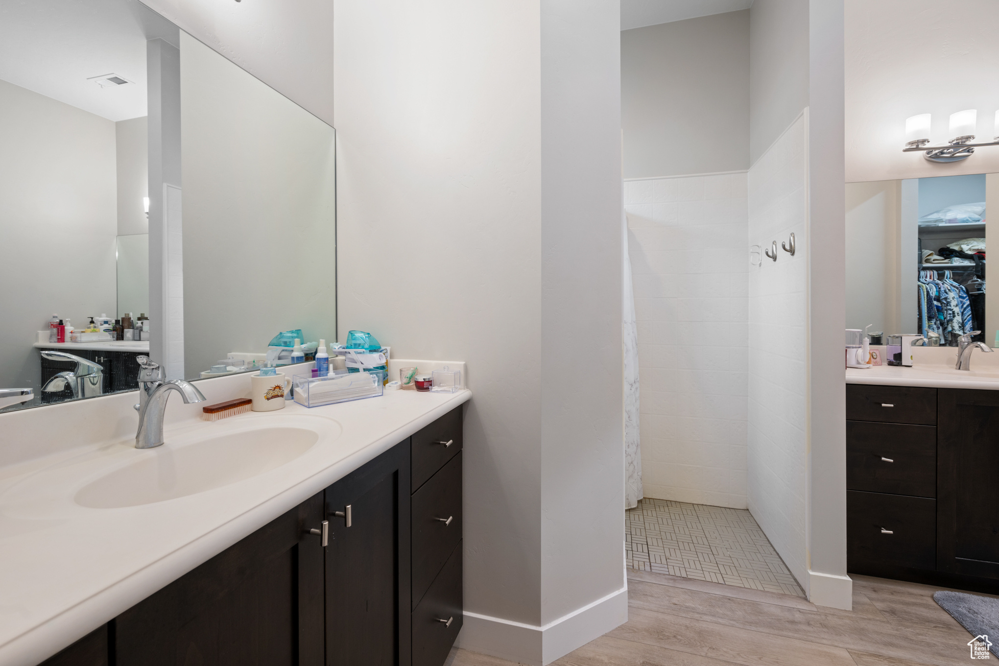 Bathroom featuring a shower, hardwood / wood-style floors, and vanity