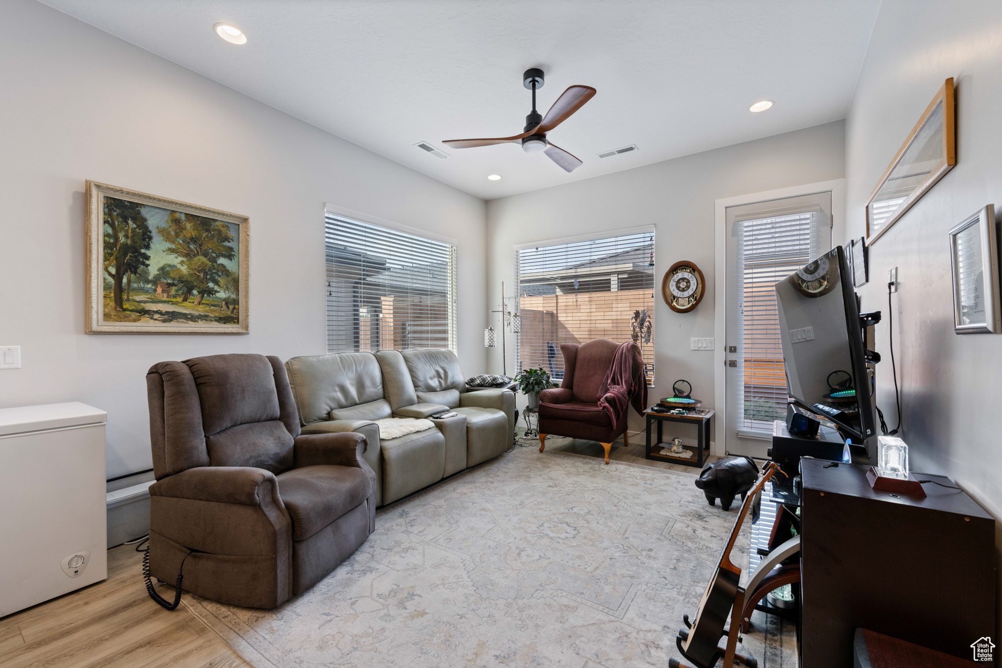 Living room with ceiling fan and light hardwood / wood-style flooring