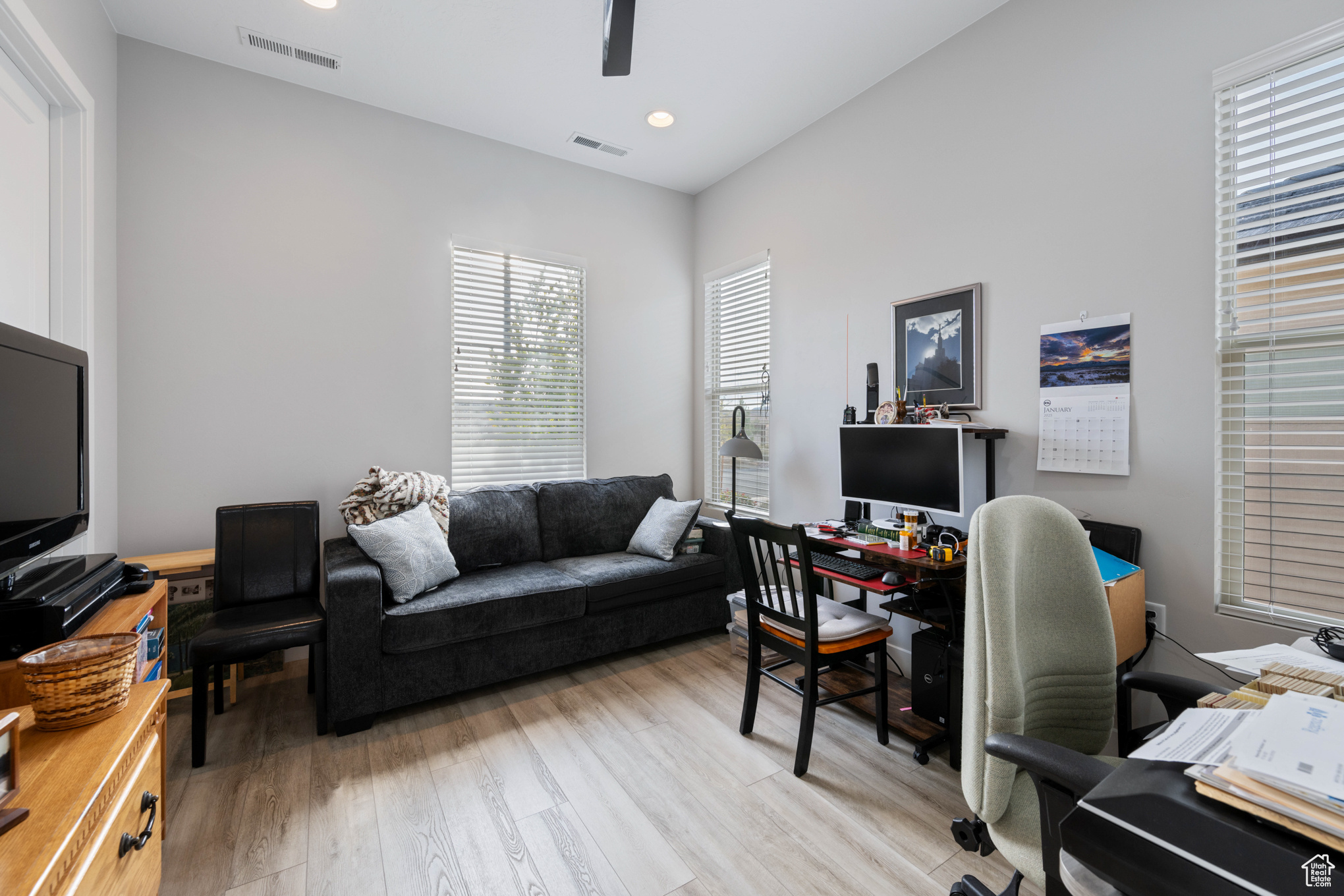 Office space with light hardwood / wood-style flooring and ceiling fan