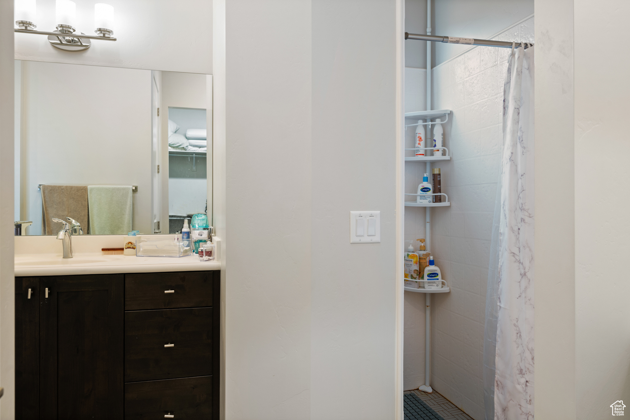 Bathroom featuring a shower with shower curtain and vanity