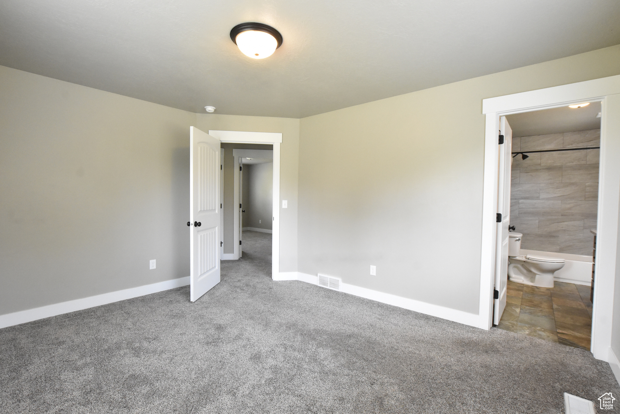 Unfurnished bedroom featuring carpet flooring and connected bathroom