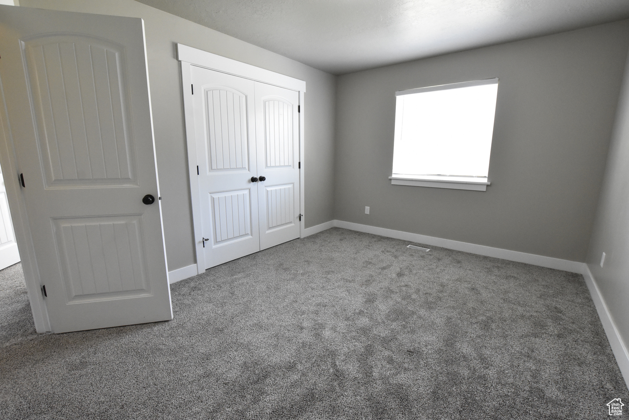 Unfurnished bedroom featuring carpet and a closet