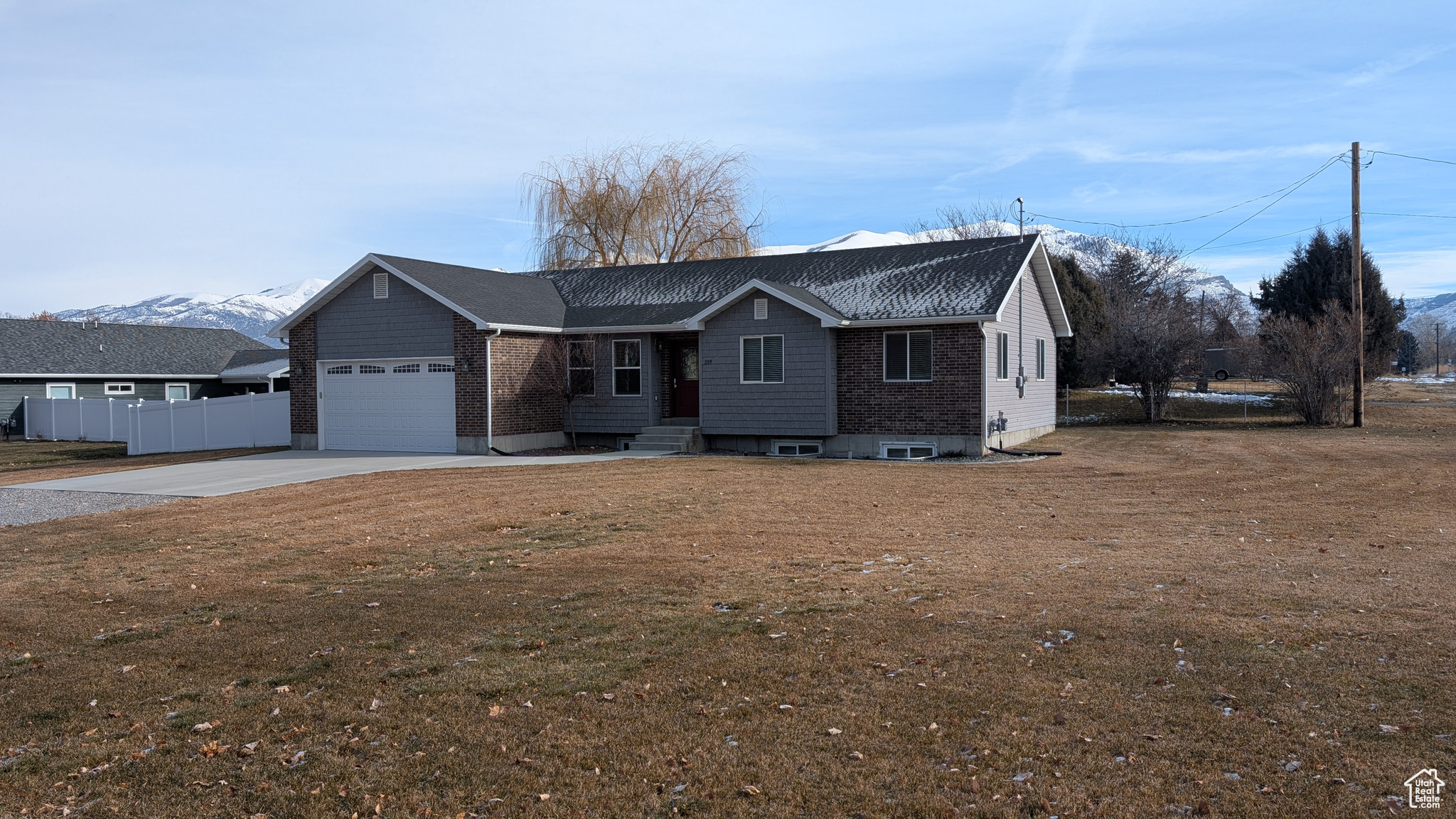 View of front of home featuring a mountain view, a garage, and a front yard