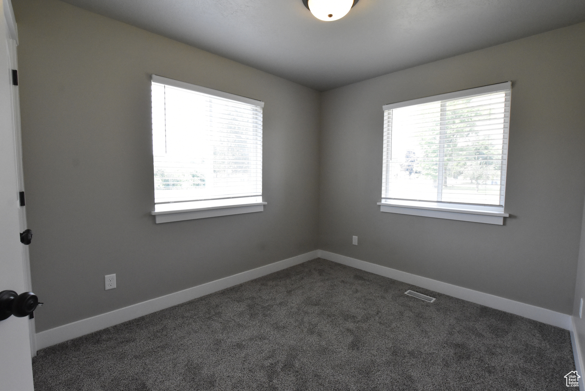 Spare room with dark colored carpet