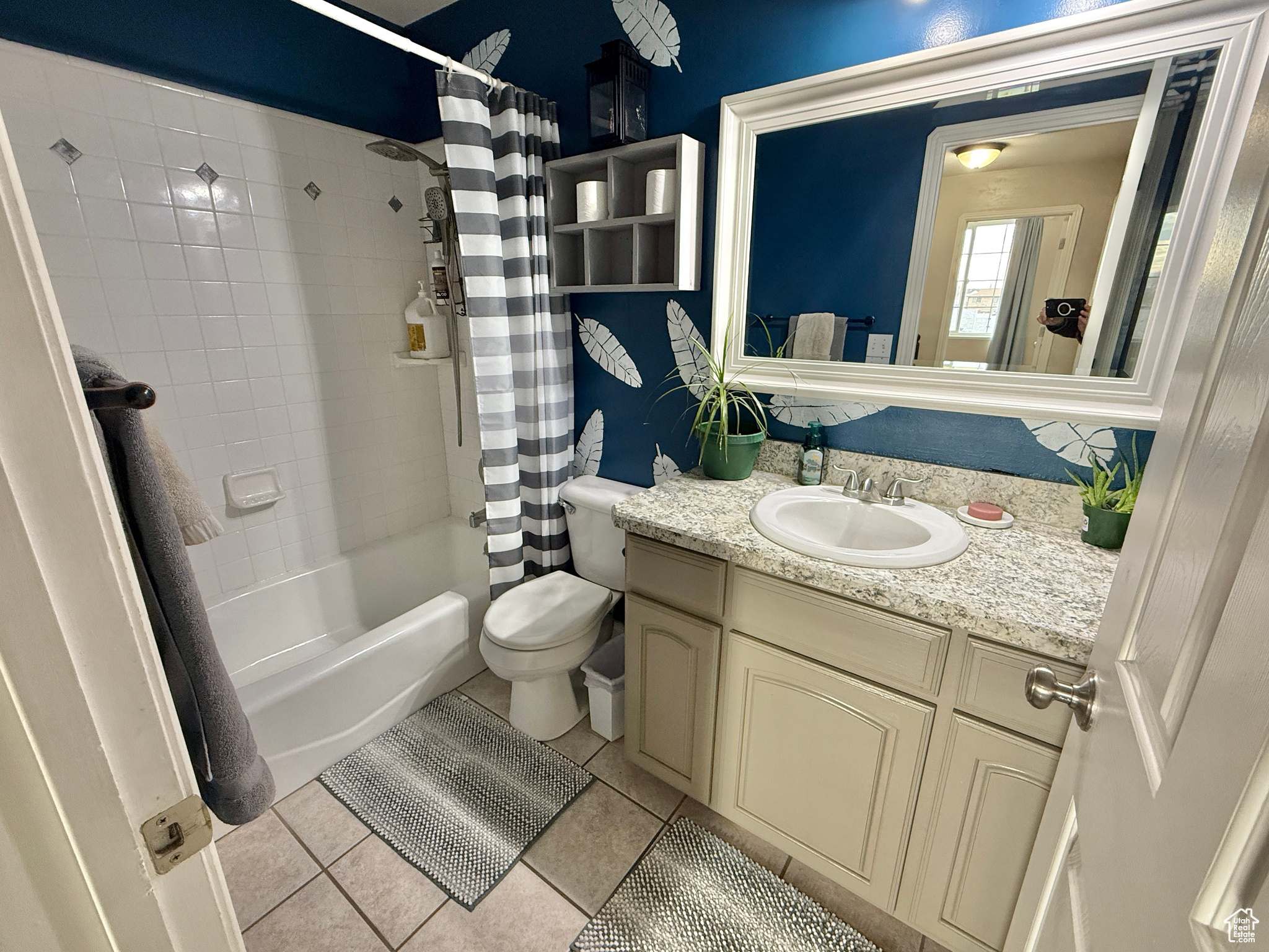 Full bathroom featuring tile patterned flooring, shower / bath combo, toilet, and vanity
