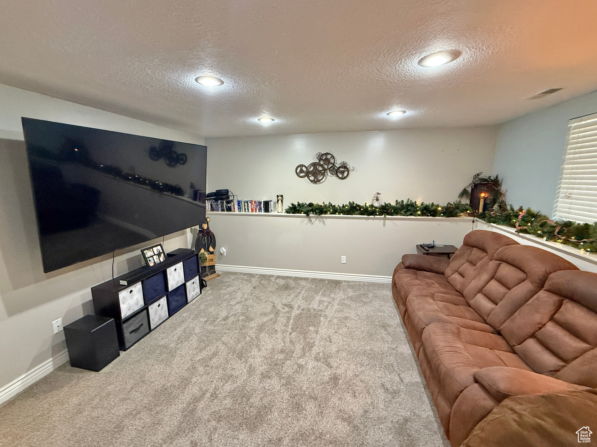 Carpeted living room featuring a textured ceiling