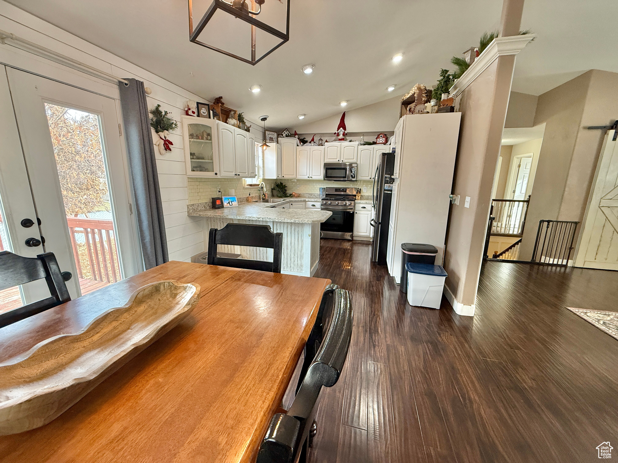 Dining area featuring vaulted ceiling, dark wood-type flooring, and sink