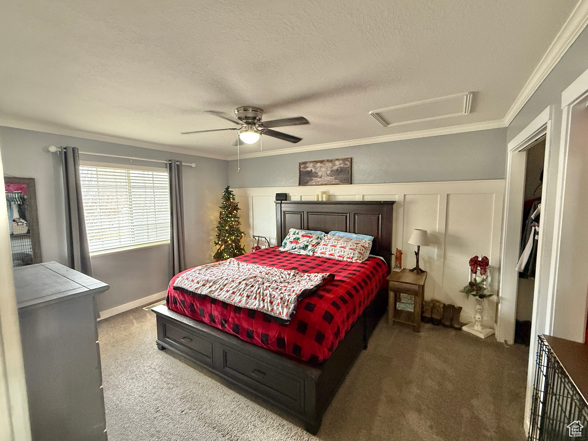 Bedroom with a textured ceiling, carpet floors, ceiling fan, and crown molding