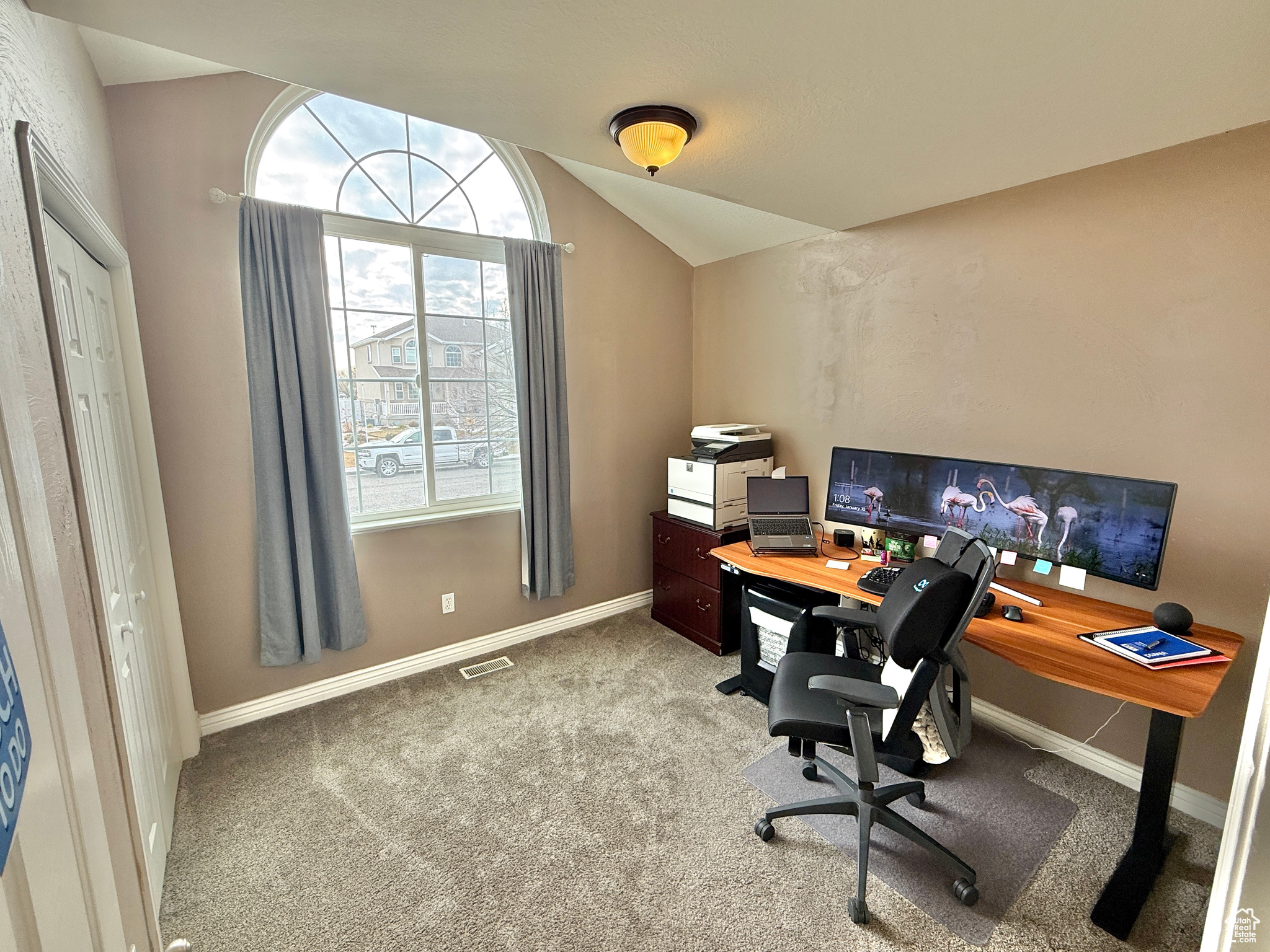 Carpeted office featuring vaulted ceiling