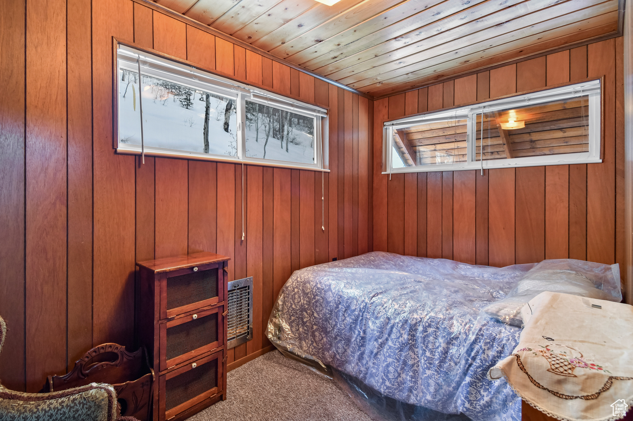 Bedroom with carpet, wood walls, and wood ceiling