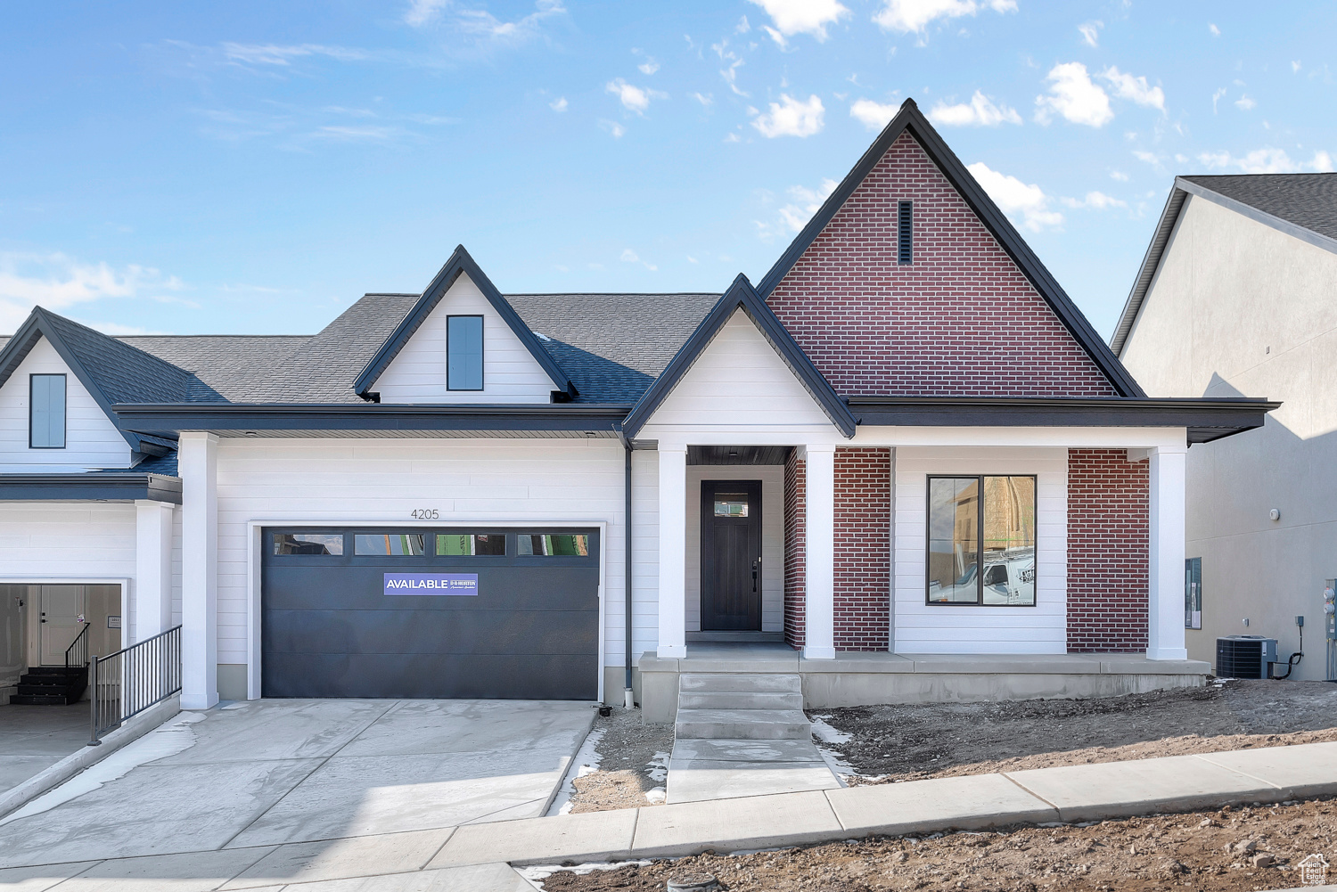 View of front of house with a garage and central AC